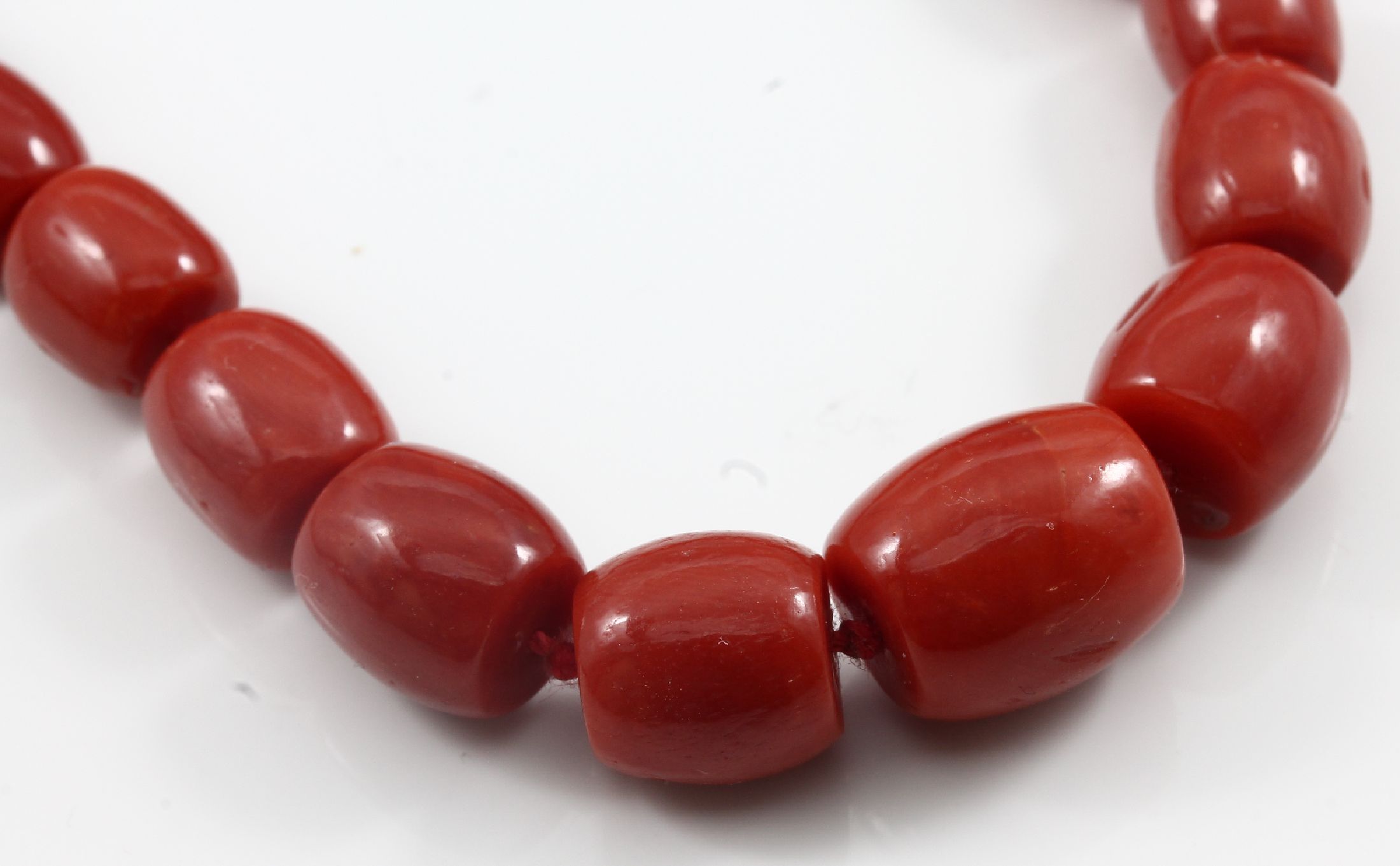 Detail e: Collier aus Korallen, Schließe GG 750/000, schleifenförmig, Korallentönnchen von guter Farbe verlaufend, L. ca. 7.3 - 12.2 mm, L. ca. 72 cm, ...