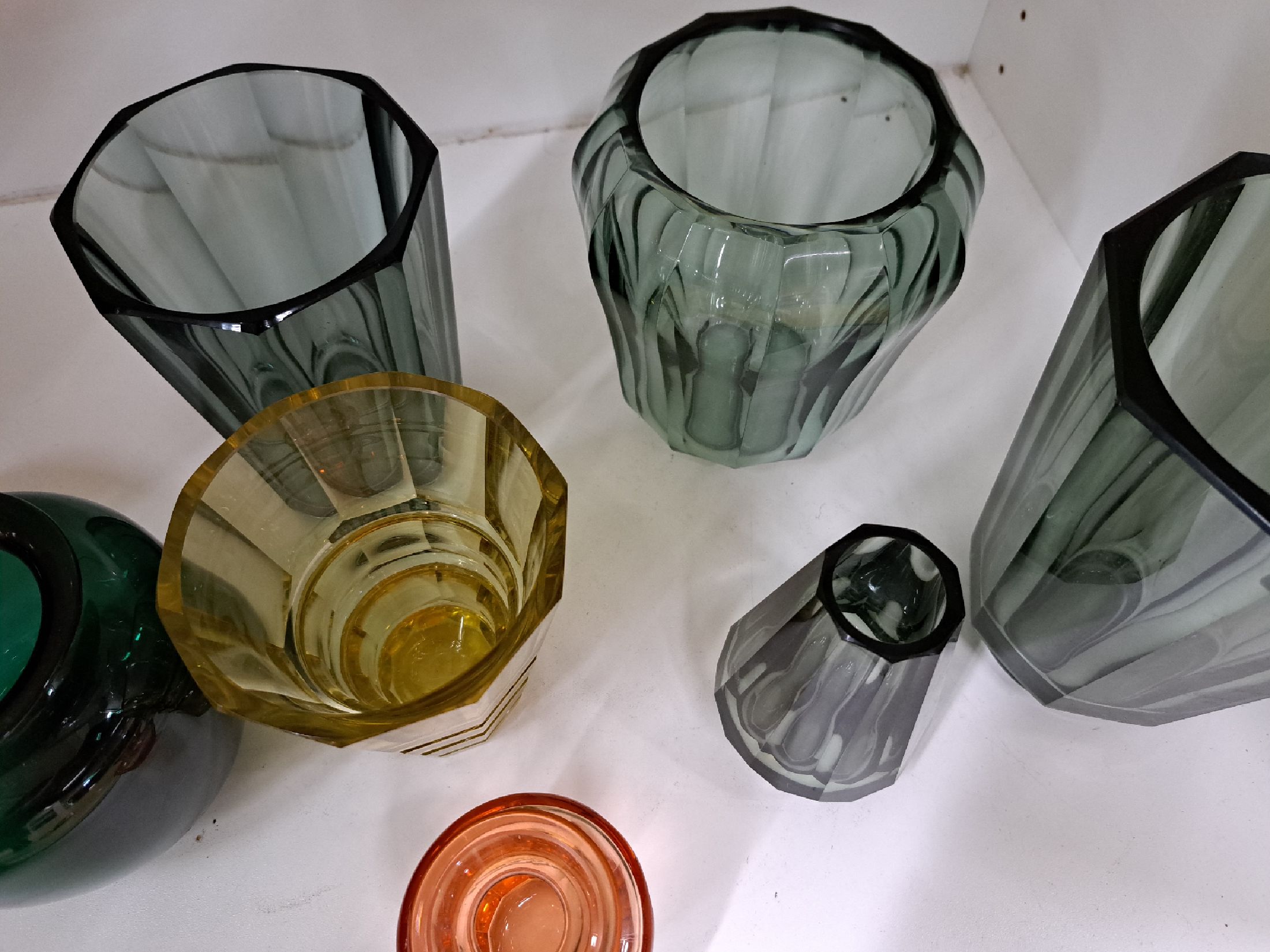Detail c: 7 Glasziervasen, Moser, 2.Hälfte 20.Jh., grün, grau und gelb eingefärbtes Glas, in Facetten geschnitten, Alterssp., H. 9-18 cm