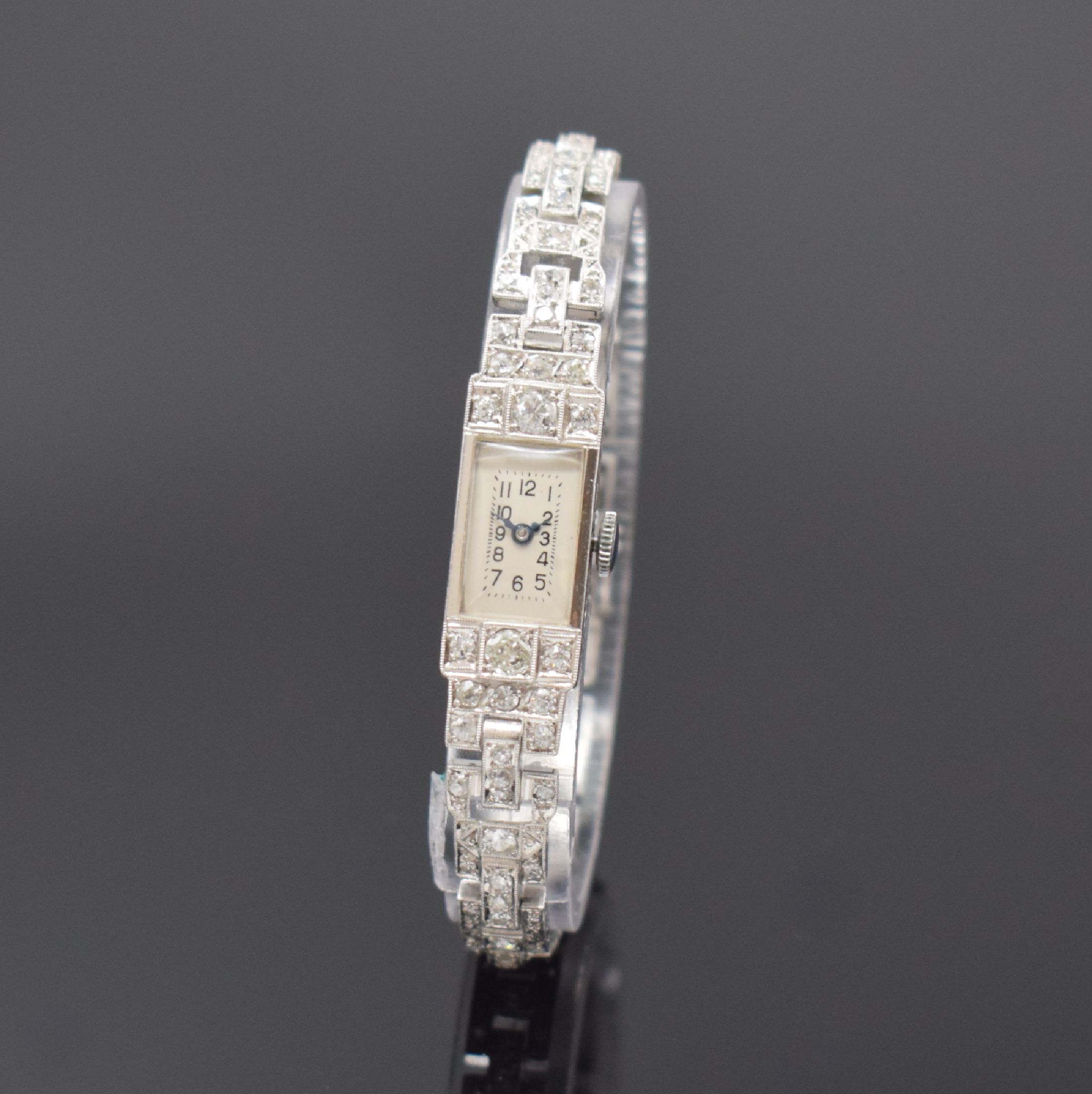 Art-Deco Armbanduhr in Platin mit Diamanten,Schweiz um 1930, Handaufzug, Scharnierboden, Band u. Geh. aufw. m. Diamanten bes., silb. Zifferbl. m. ...