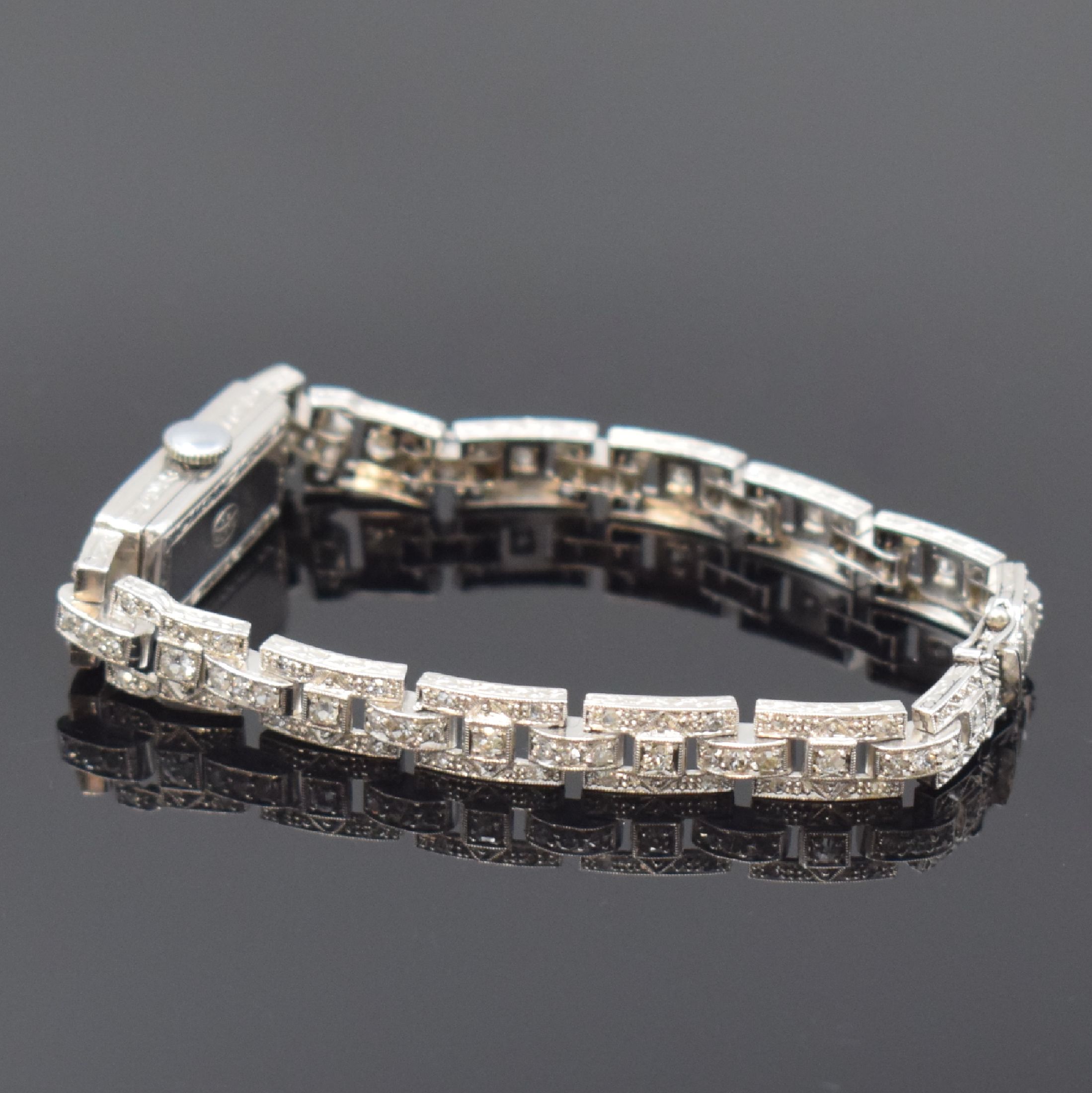 Detail b: Art-Deco Armbanduhr in Platin mit Diamanten,Schweiz um 1930, Handaufzug, Scharnierboden, Band u. Geh. aufw. m. Diamanten bes., silb. Zifferbl. m. ...
