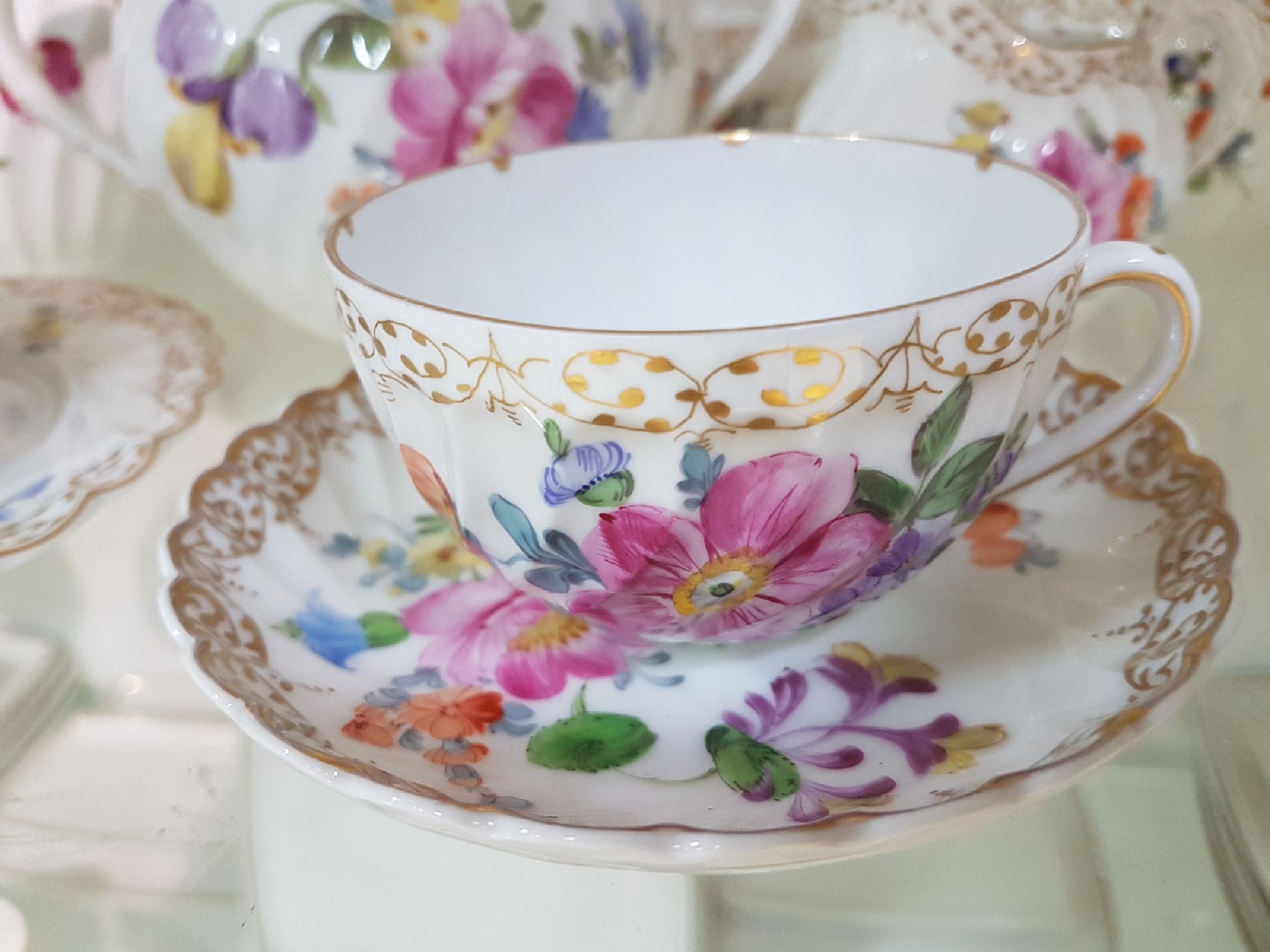 Detail d: Kaffee- bzw. Teeservice, Nymphenburg, 20. Jh., Fächerrelief, bunter Blumendekor, Goldspitzenränder, gr. und kleine Kanne, 2 Milch-bzw. ...