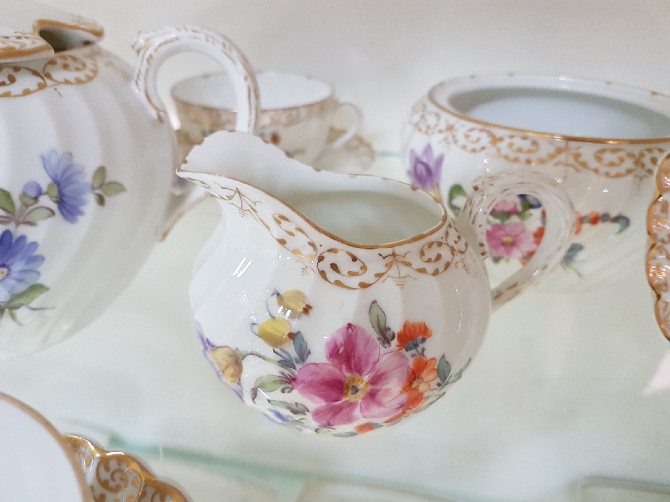 Detail f: Kaffee- bzw. Teeservice, Nymphenburg, 20. Jh., Fächerrelief, bunter Blumendekor, Goldspitzenränder, gr. und kleine Kanne, 2 Milch-bzw. ...