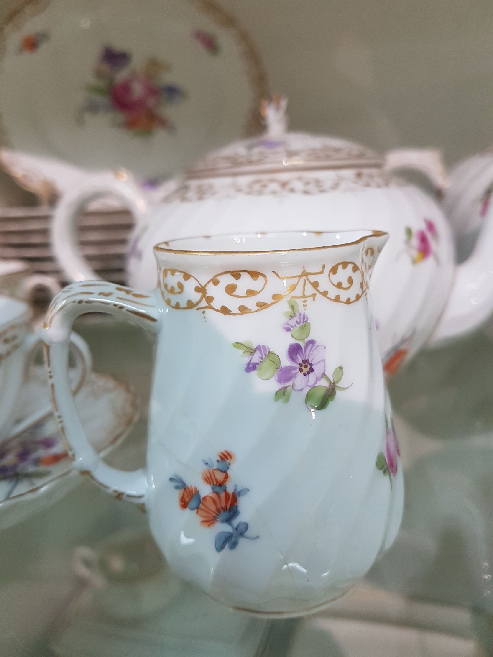 Detail g: Kaffee- bzw. Teeservice, Nymphenburg, 20. Jh., Fächerrelief, bunter Blumendekor, Goldspitzenränder, gr. und kleine Kanne, 2 Milch-bzw. ...