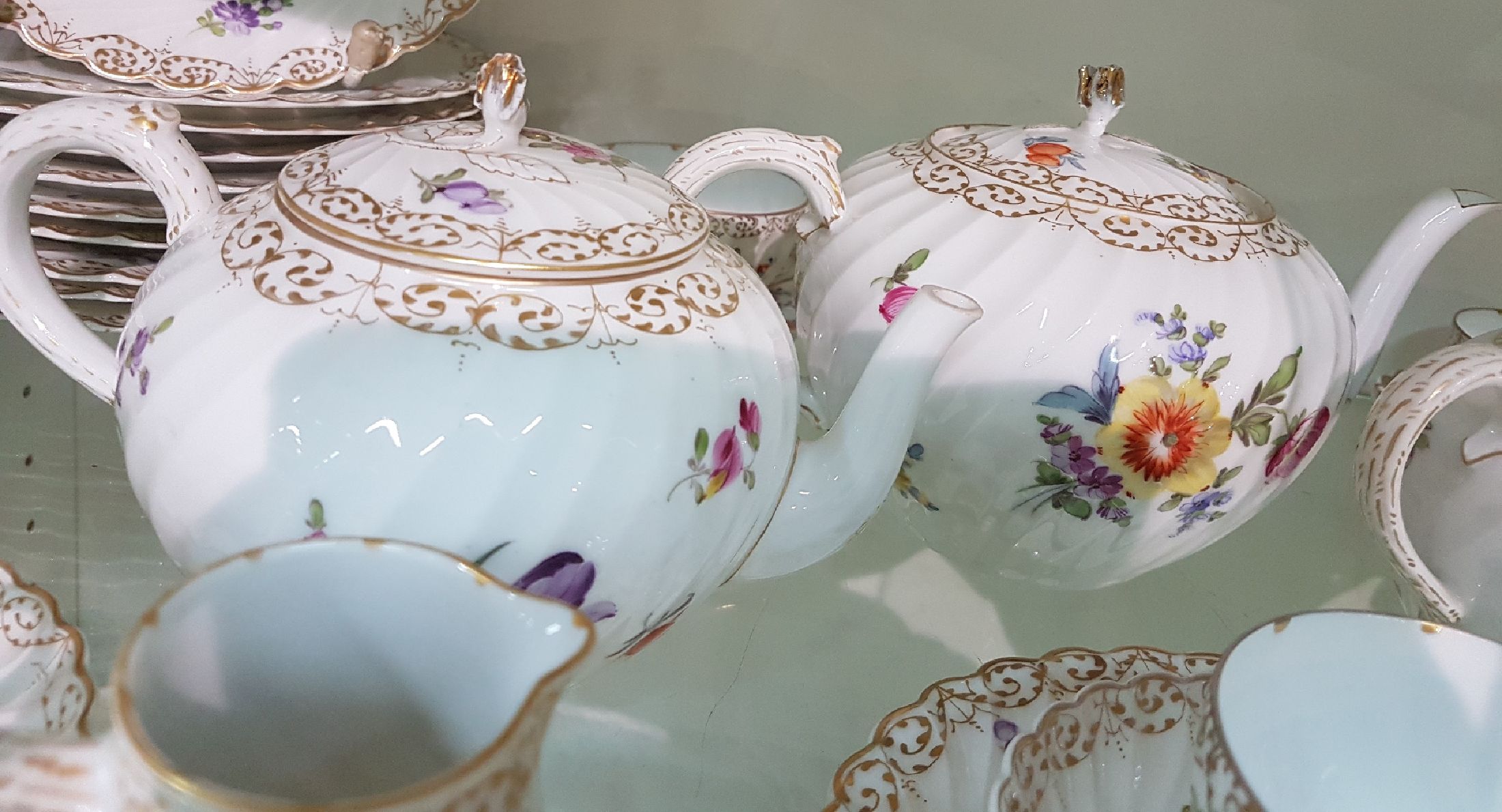 Detail h: Kaffee- bzw. Teeservice, Nymphenburg, 20. Jh., Fächerrelief, bunter Blumendekor, Goldspitzenränder, gr. und kleine Kanne, 2 Milch-bzw. ...