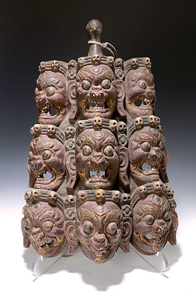 Wandapplike, Nepal/Tibet, 20. Jh., Holz geschnitzt mit 9 Mahakala-Gesichtern und Totenköpfen, Rot und Weiß gefaßt, ca. 46x30cm