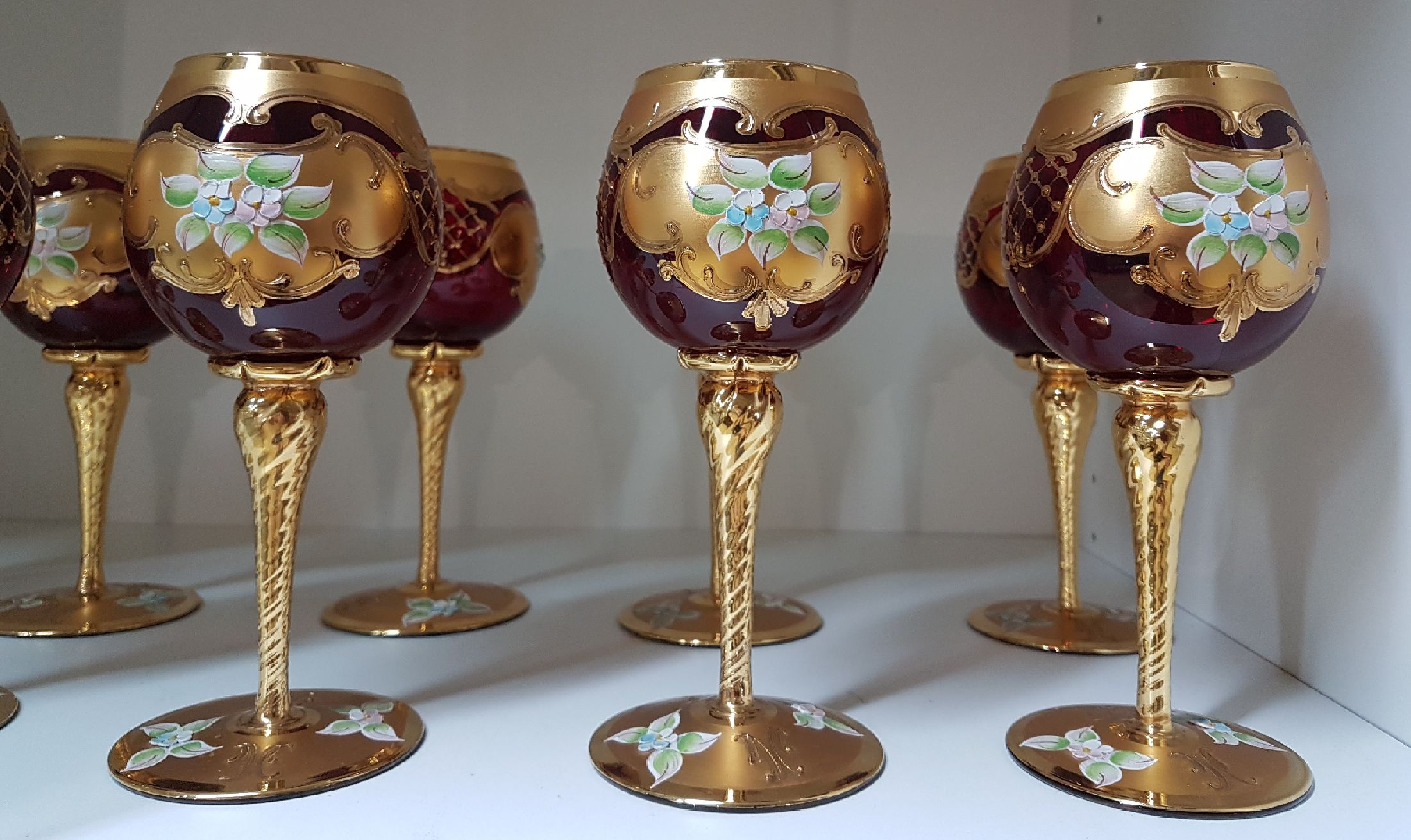 Detail a: 12 Weingläser, Murano Italien, 1970er Jahre, rubinrotes Glas, reich vergoldet und mit bunter floraler Emailmalerei, H. je ca. 19.5cm