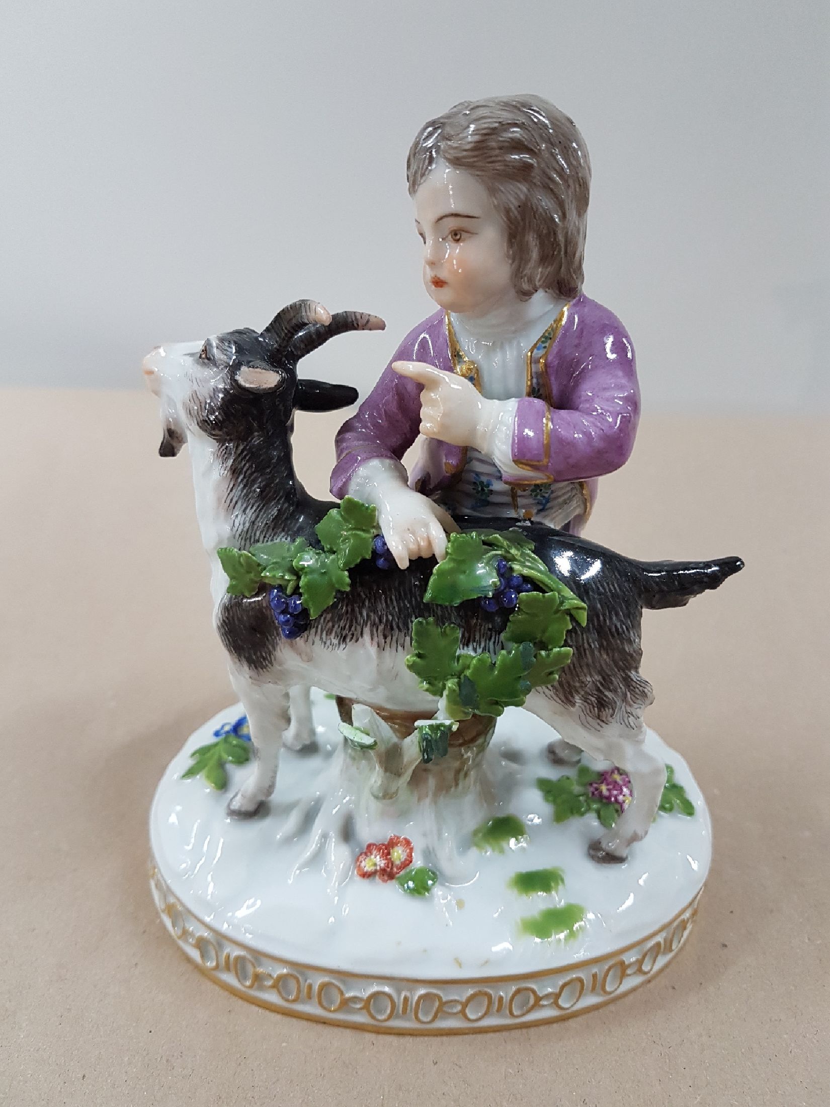 Detail a: Porzellanfigur, Meissen, vor 1924, Modell H 82, Knabe mit Ziegen, Entwurf Johann Carl Schönheit, Porzellan, polychrom bemalt, am Blattwerk besch., ...