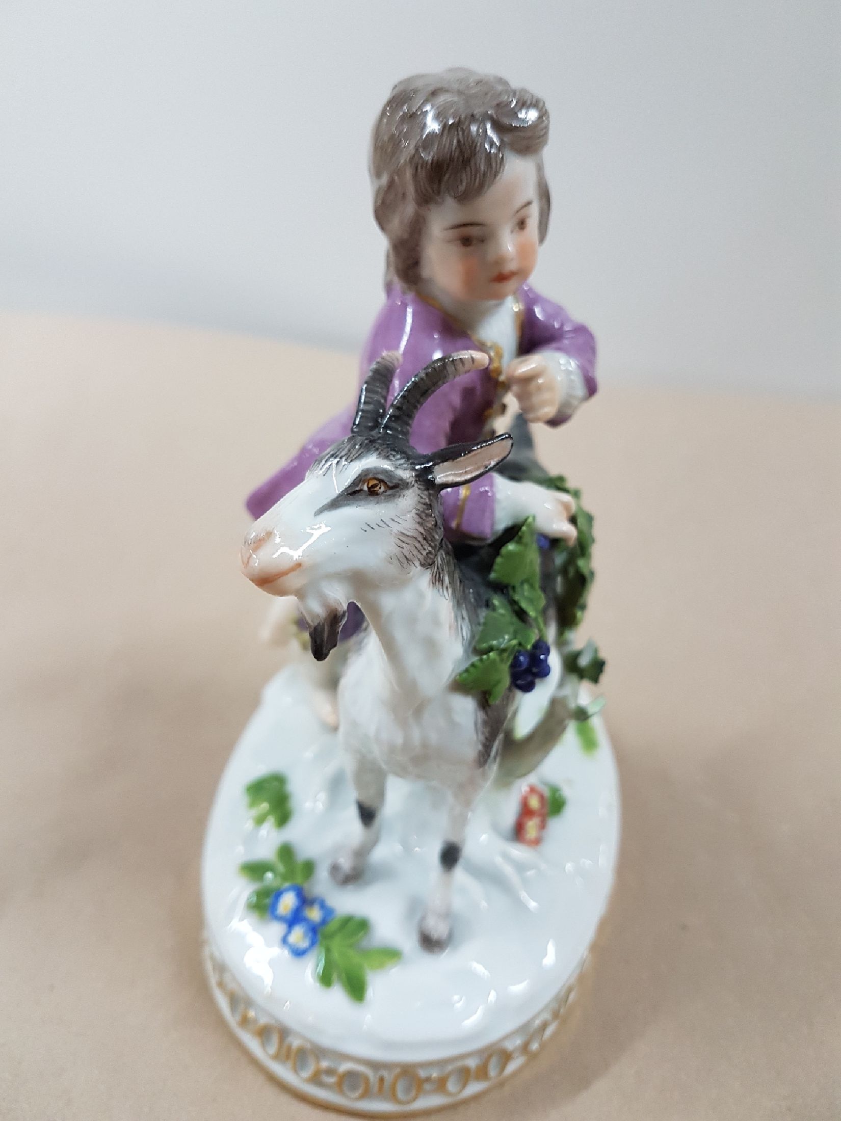 Detail b: Porzellanfigur, Meissen, vor 1924, Modell H 82, Knabe mit Ziegen, Entwurf Johann Carl Schönheit, Porzellan, polychrom bemalt, am Blattwerk besch., ...
