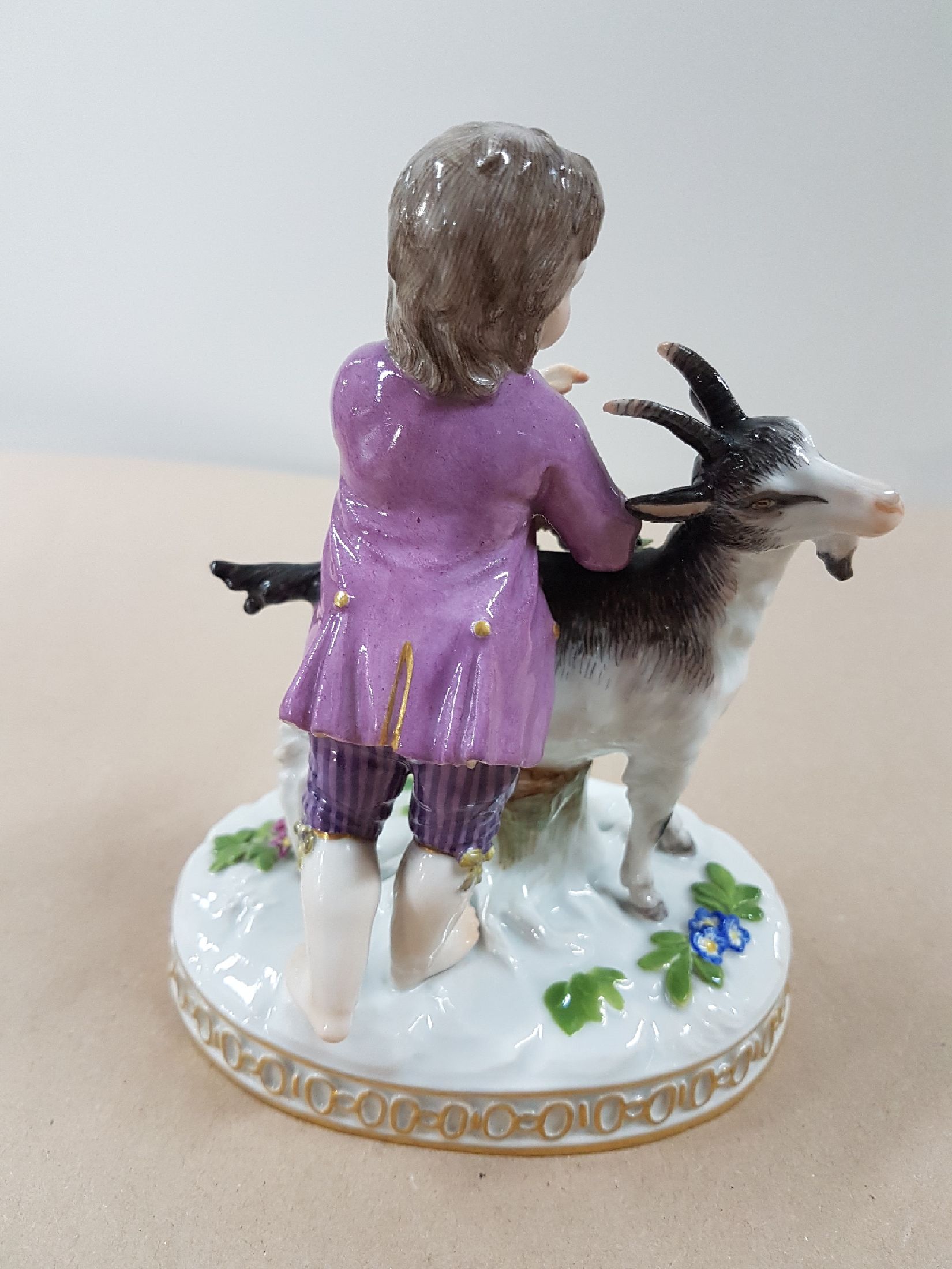 Detail c: Porzellanfigur, Meissen, vor 1924, Modell H 82, Knabe mit Ziegen, Entwurf Johann Carl Schönheit, Porzellan, polychrom bemalt, am Blattwerk besch., ...