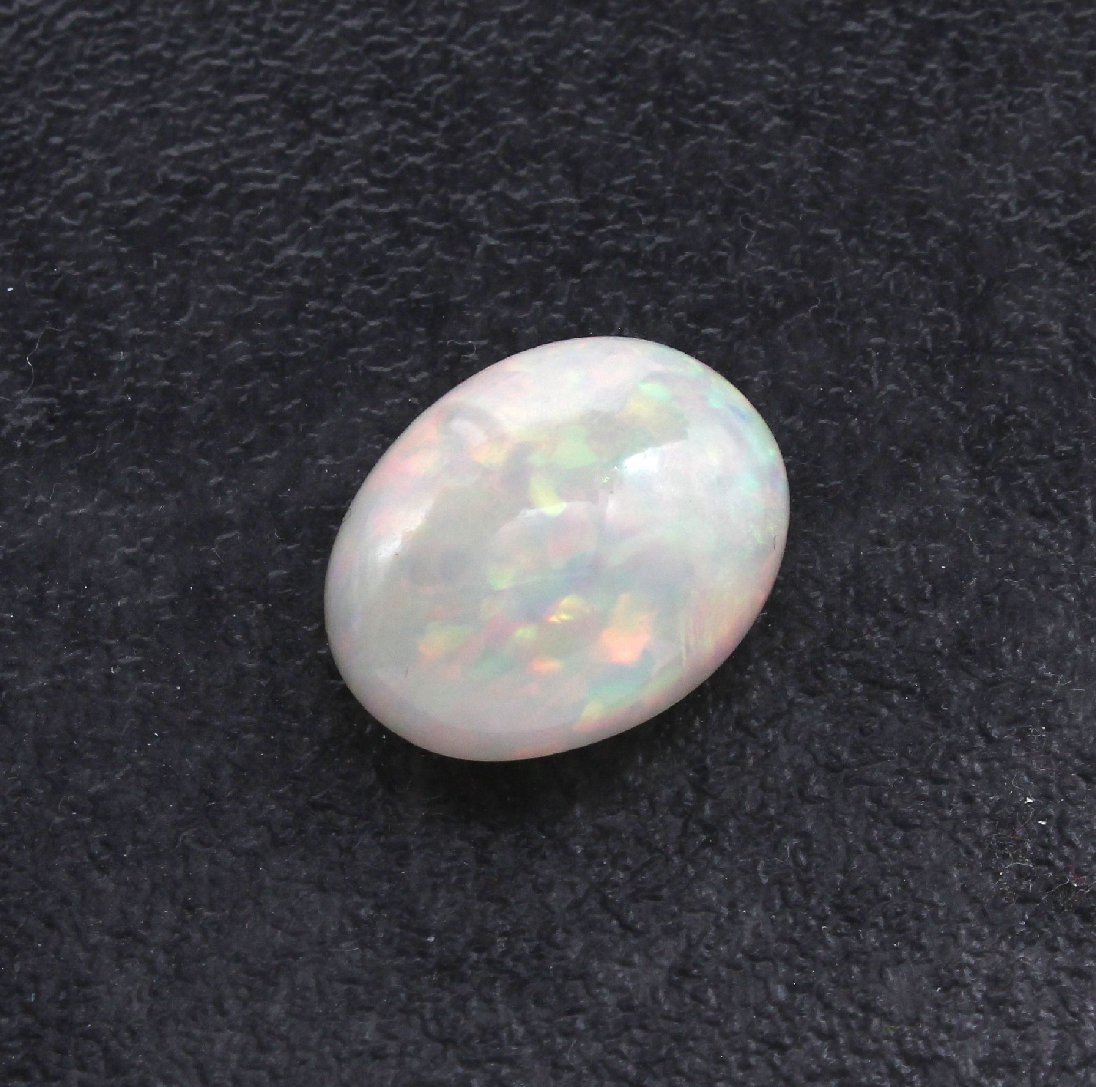 Detail a: Loser Opal, ca. 10.48 ct, ovaler Cabochon, schönes Farbspiel in Rot und Grün, mit PGTL- Expertise