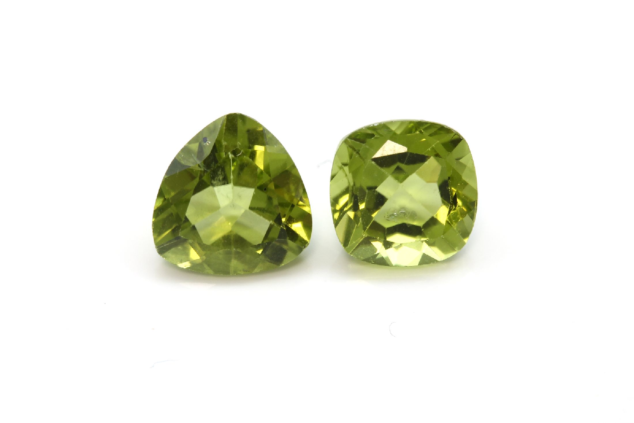 Lot 8 lose Peridots, zus. ca. 20.4 ct, 4 Peridots in facett. Triangelform zus. ca. 10.50 ct und 4 Peridots im facett. Kissen- schliff zus. ca. 9.90 ...