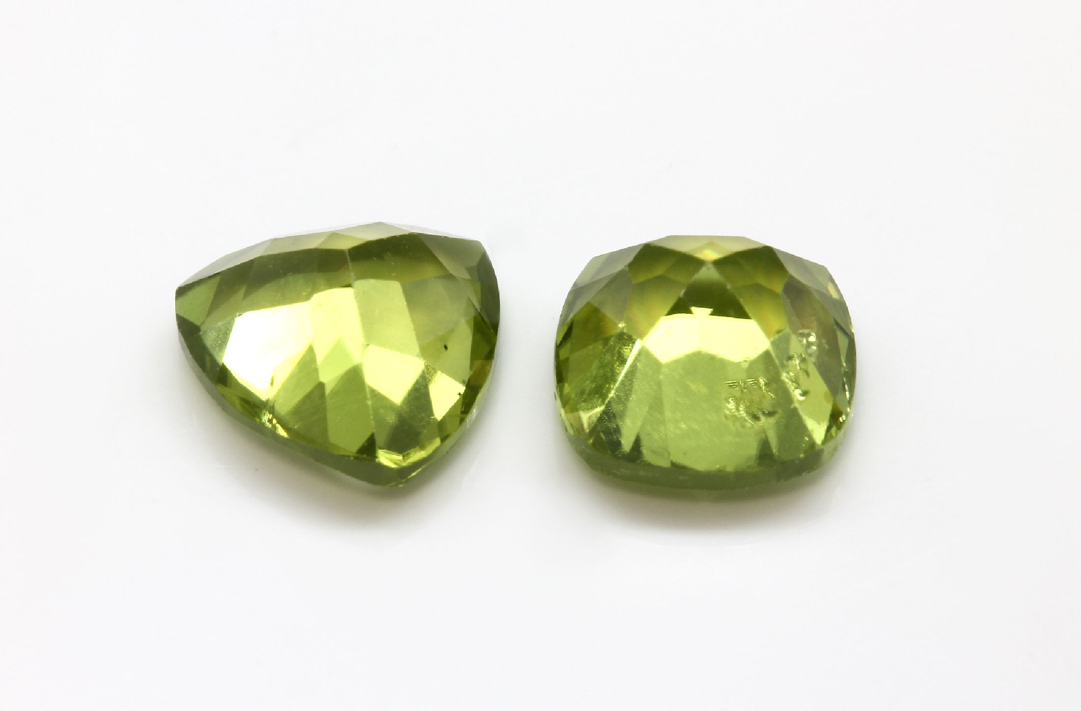 Detail a: Lot 8 lose Peridots, zus. ca. 20.4 ct, 4 Peridots in facett. Triangelform zus. ca. 10.50 ct und 4 Peridots im facett. Kissen- schliff zus. ca. 9.90 ...