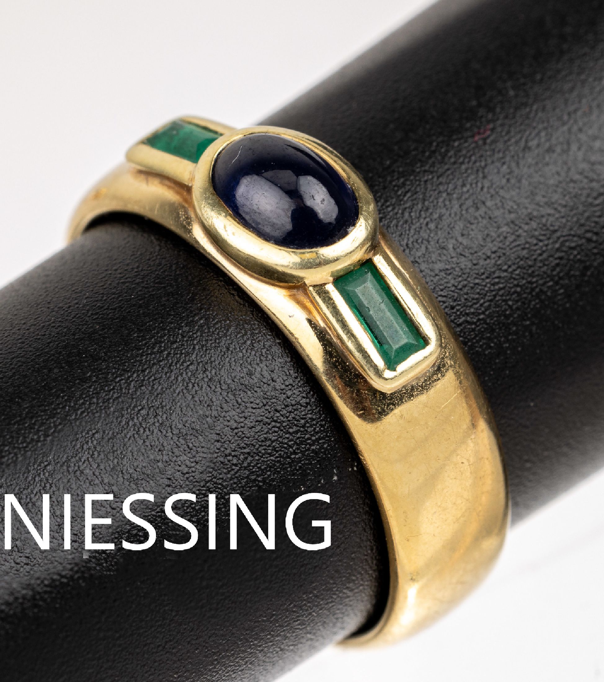 14 kt Gold NIESSING Saphir-Smaragd-Ring, GG585/000, mittig ovaler Saphir-Cabochon ca. 1.0 ct, seitl. 2 Smaragde im Treppenschliff ca. 0.20 ct, RW ...