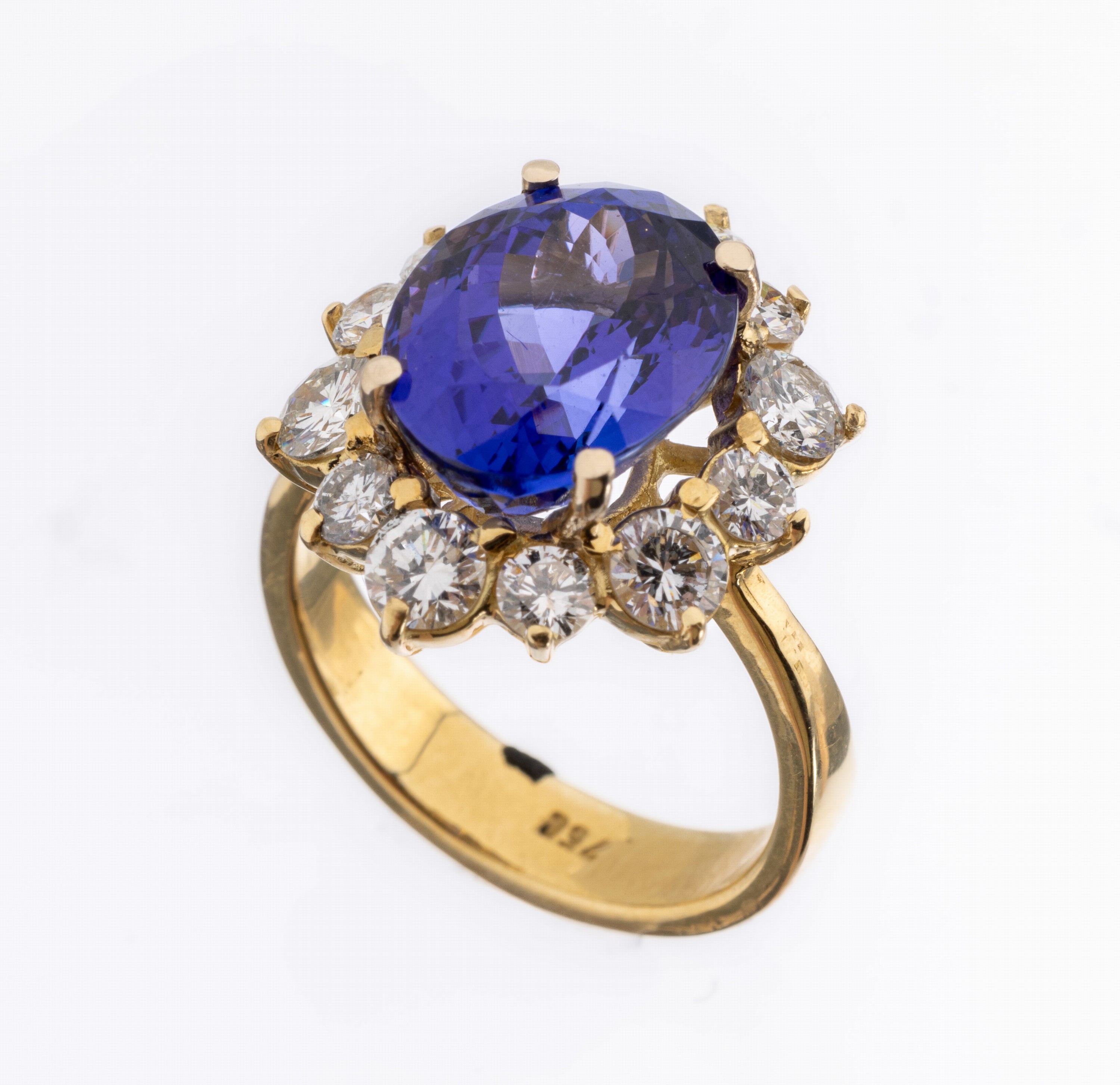 18 kt Gold Tansanit-Brillant-Ring, GG 750/ 000, mittig erhaben gefasster ovalfacett. Tansanit ca. 6.25 ct, umgeben von 12 Brillan- ten zus. ca. 1.70 ...