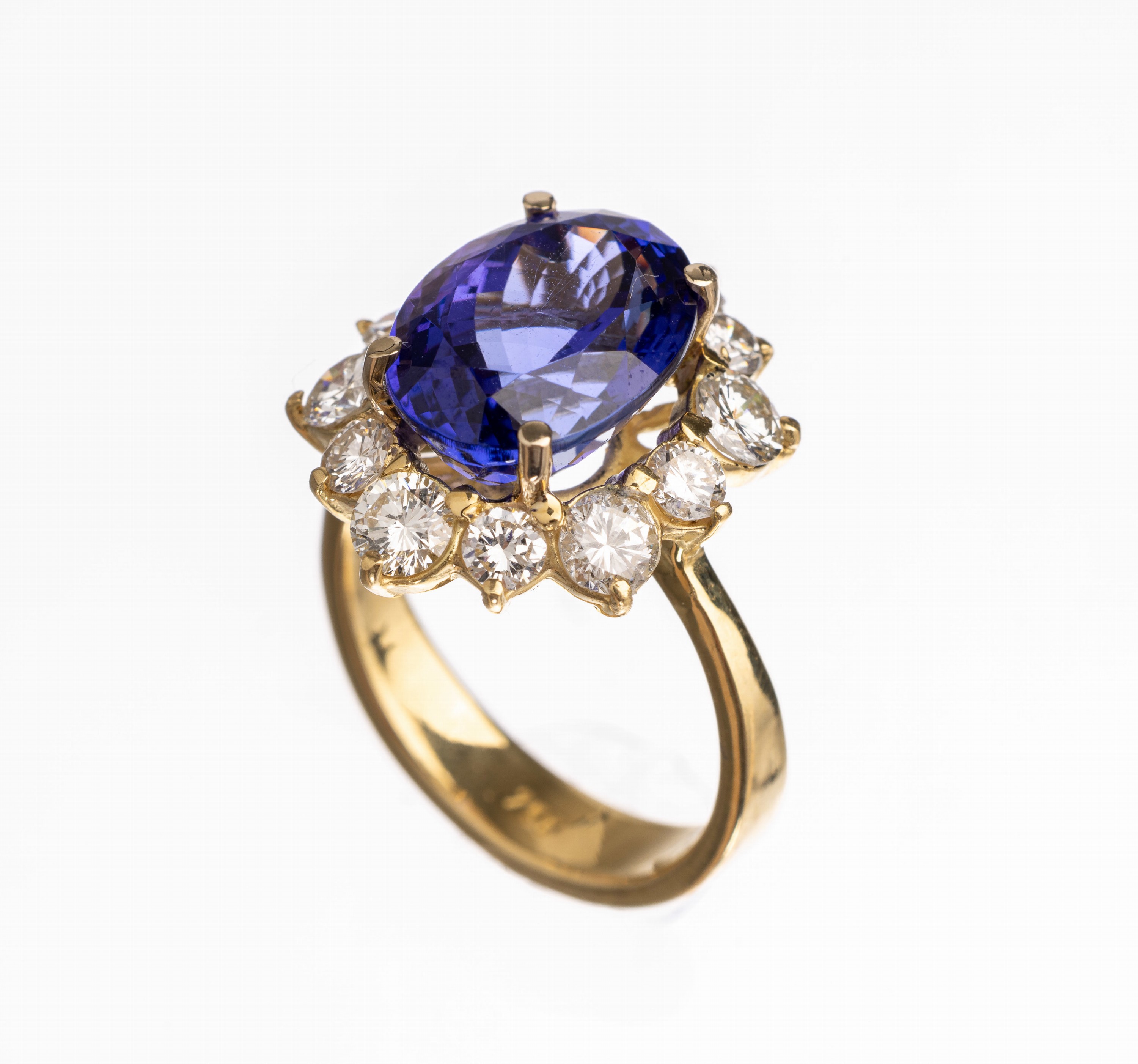 Detail a: 18 kt Gold Tansanit-Brillant-Ring, GG 750/ 000, mittig erhaben gefasster ovalfacett. Tansanit ca. 6.25 ct, umgeben von 12 Brillan- ten zus. ca. 1.70 ...