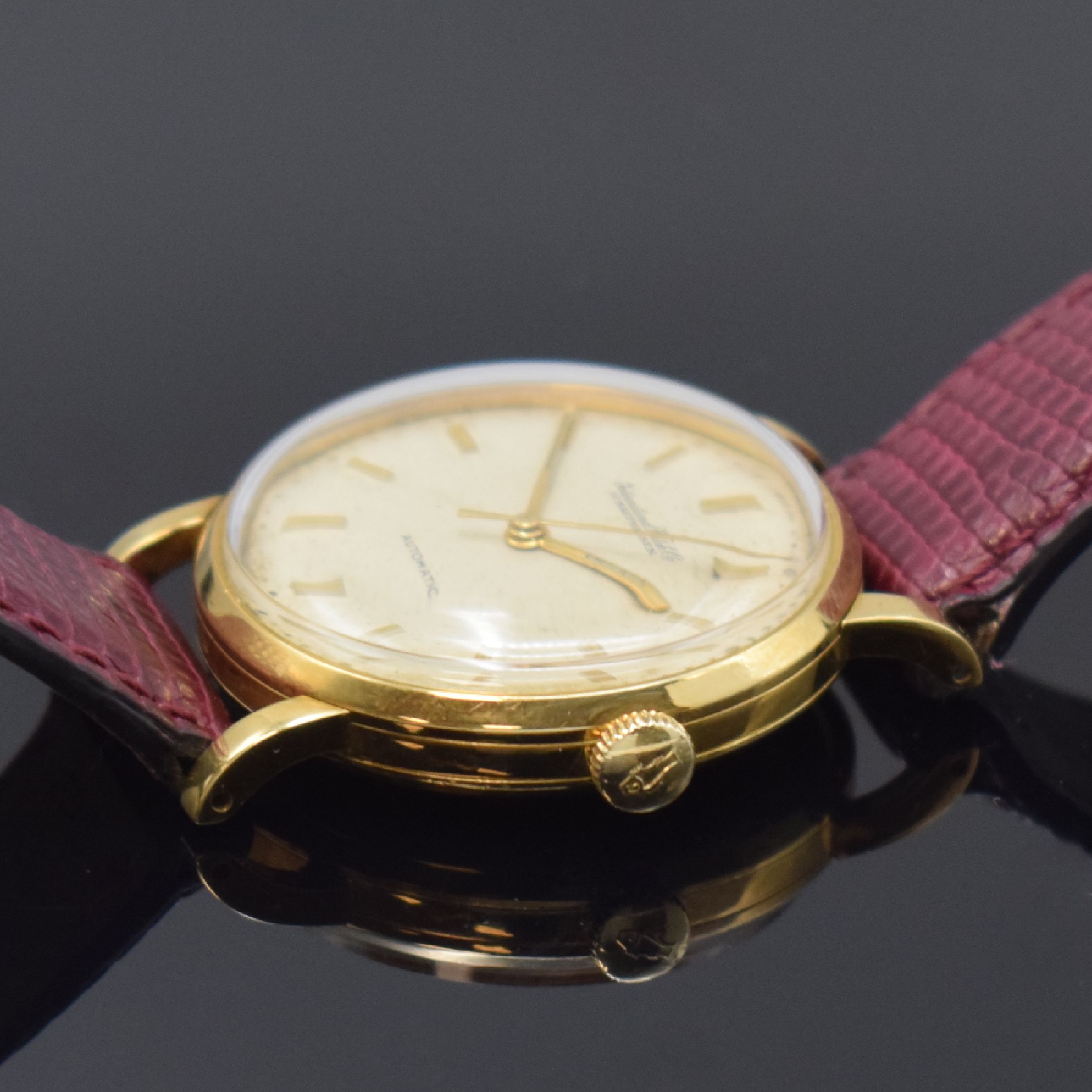Detail b: IWC Herrenarmbanduhr in GG 750/000, Schweiz um 1957, Automatik, 3-teil. Geh. l. dell., Boden und Glasrand aufgedr., silb. Zifferbl. mit aufges. gold. ...