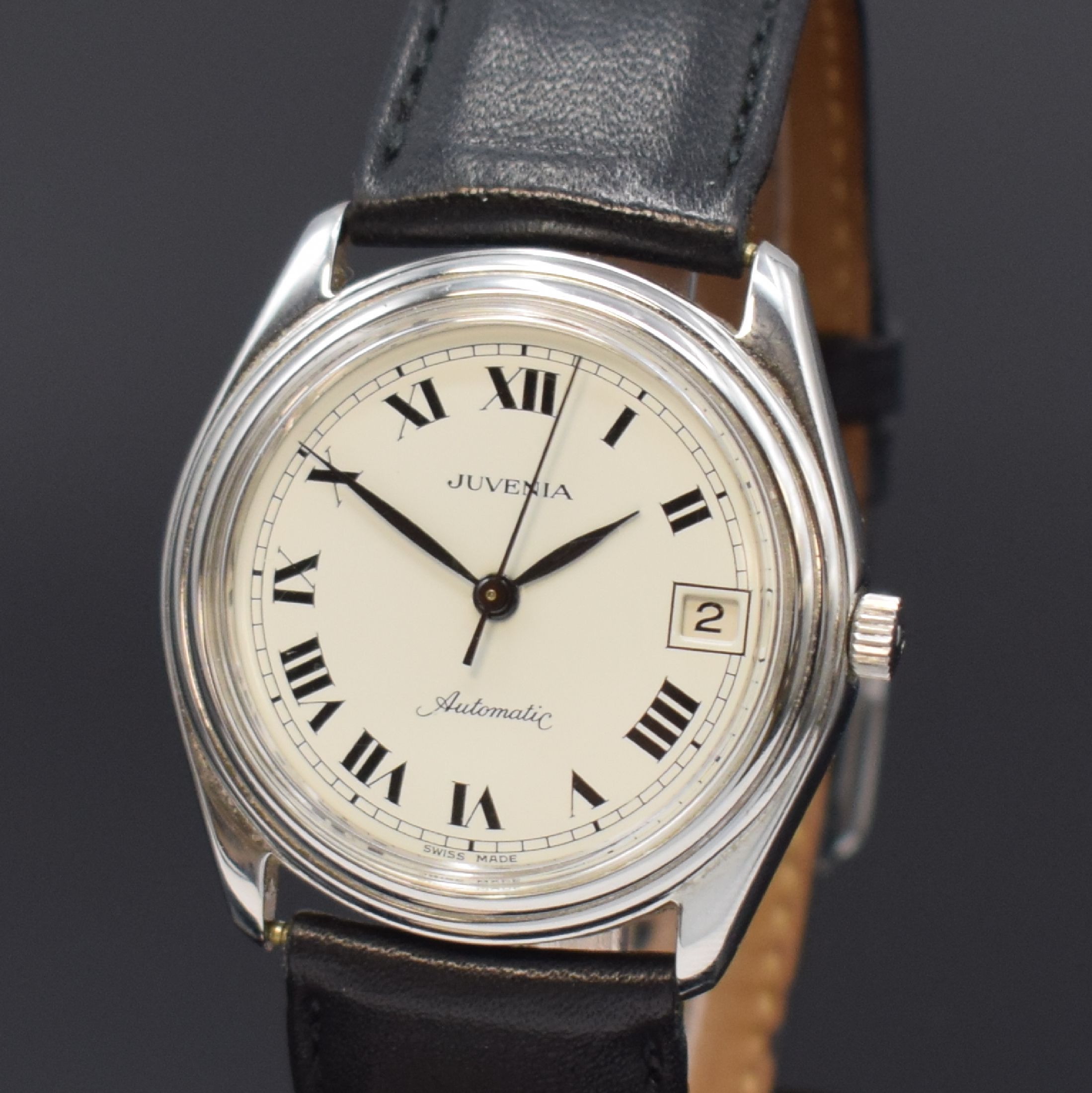 Detail a: JUVENIA Armbanduhr in Stahl, Schweiz um 1965, Boden verschr., cremefarb. Zifferbl. m. röm. Std., geschw. Zeiger, Datum bei 3, vern. Werk Kal. MFG ...