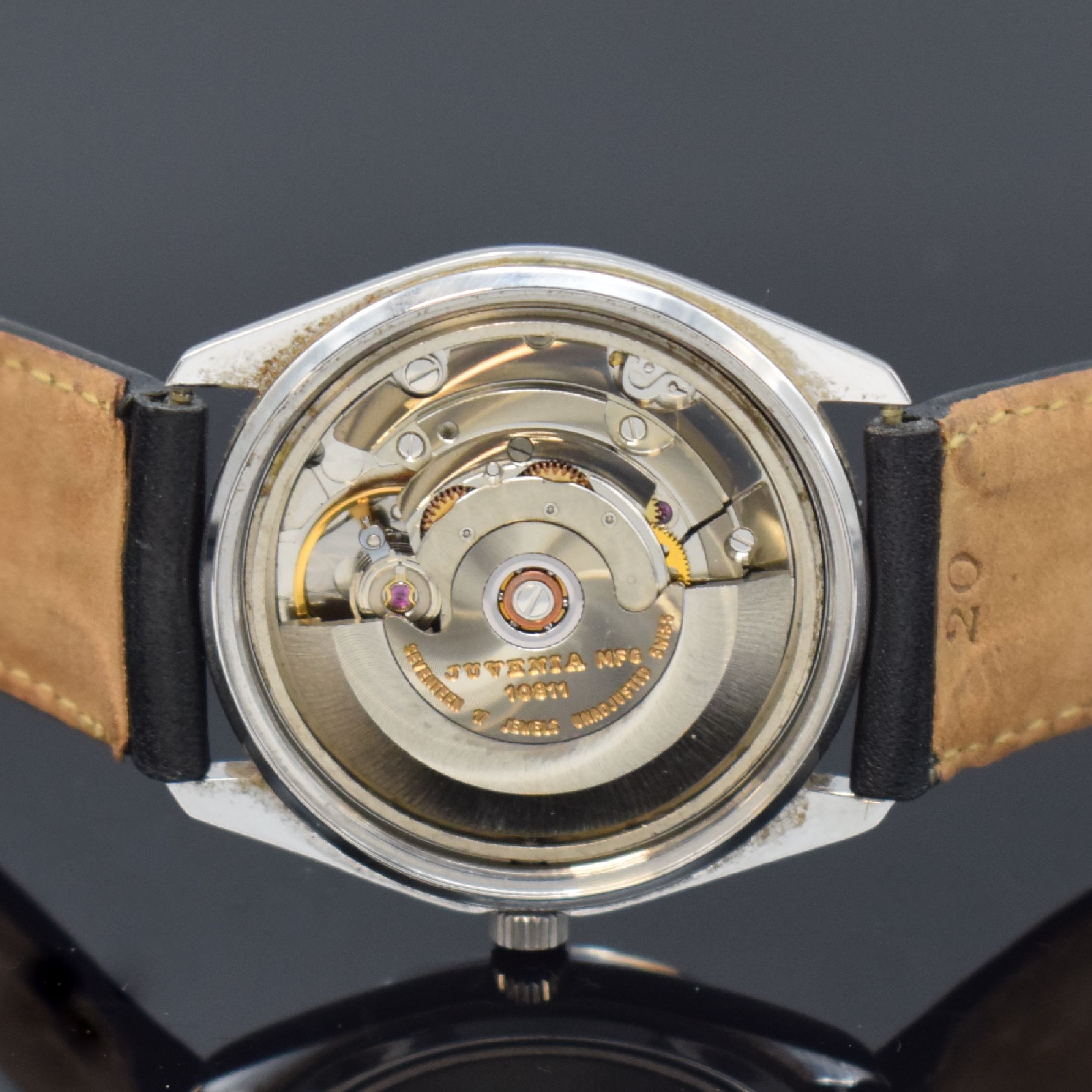 Detail e: JUVENIA Armbanduhr in Stahl, Schweiz um 1965, Boden verschr., cremefarb. Zifferbl. m. röm. Std., geschw. Zeiger, Datum bei 3, vern. Werk Kal. MFG ...