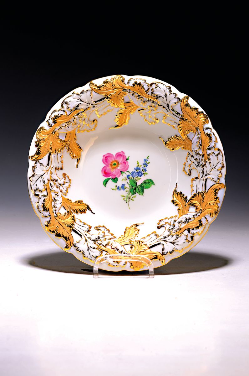 Prunkteller, Meissen, 1970er Jahre, Porzellan, reich reliefiert und matt- und glanzvergoldet, mittig Blumenmalerei, H. ca. 4cm, D. ca. 26cm
