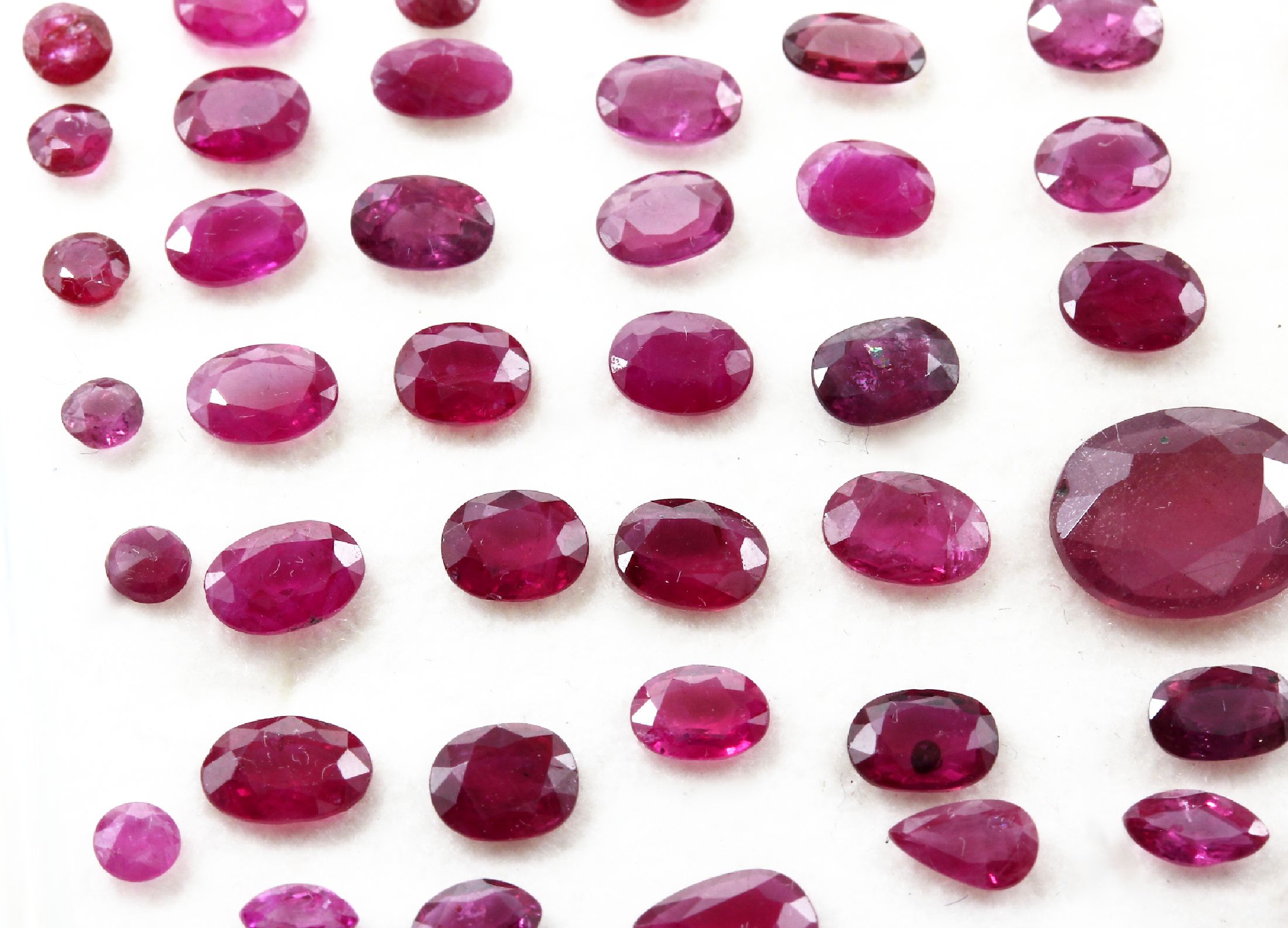 Detail b: Lot lose Farbsteine zus. ca. 127.90 ct, Granate in versch. Größen und Formen, Smaragd-und Saphircabochons