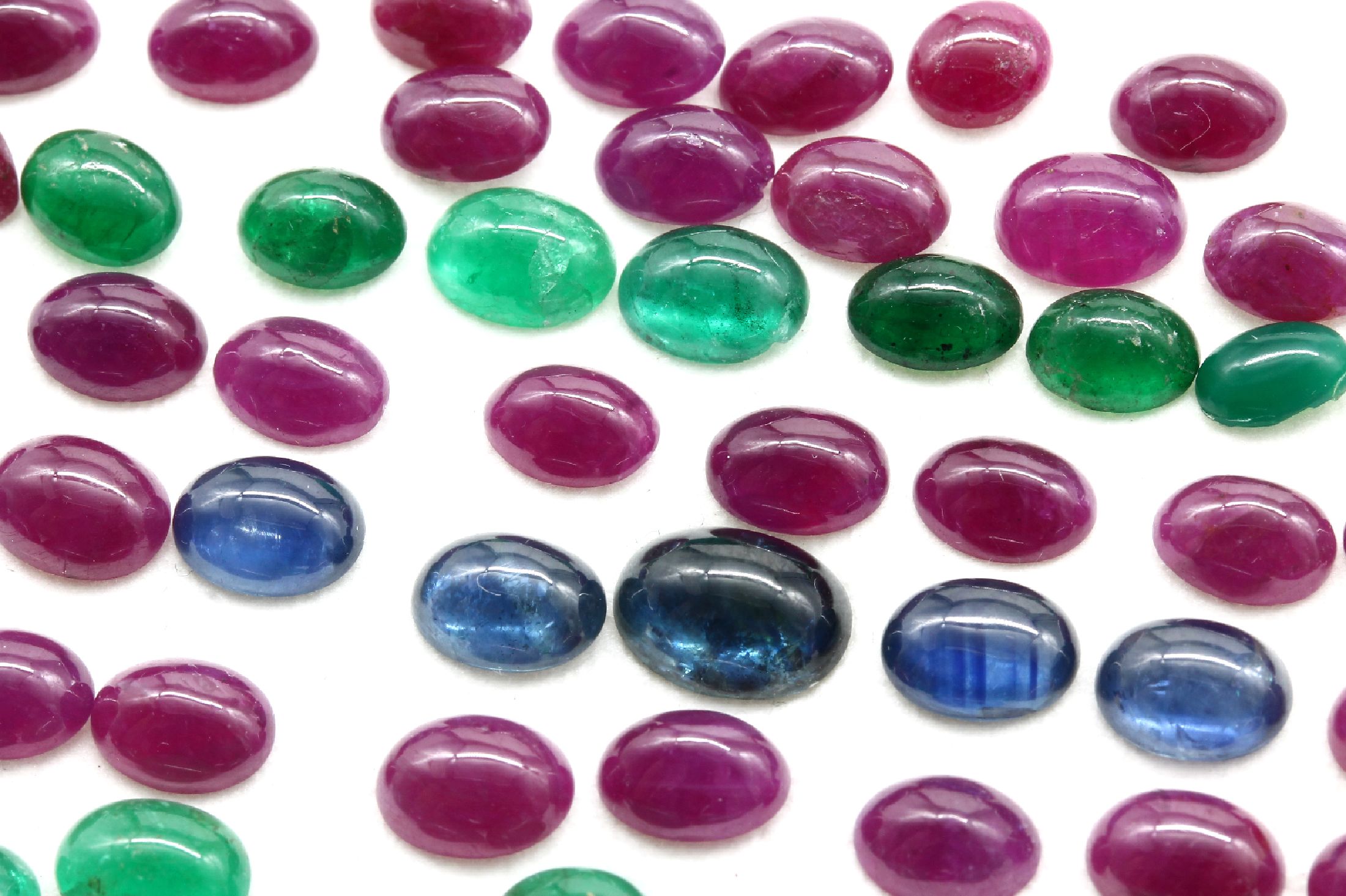 Detail c: Lot lose Farbsteine zus. ca. 127.90 ct, Granate in versch. Größen und Formen, Smaragd-und Saphircabochons