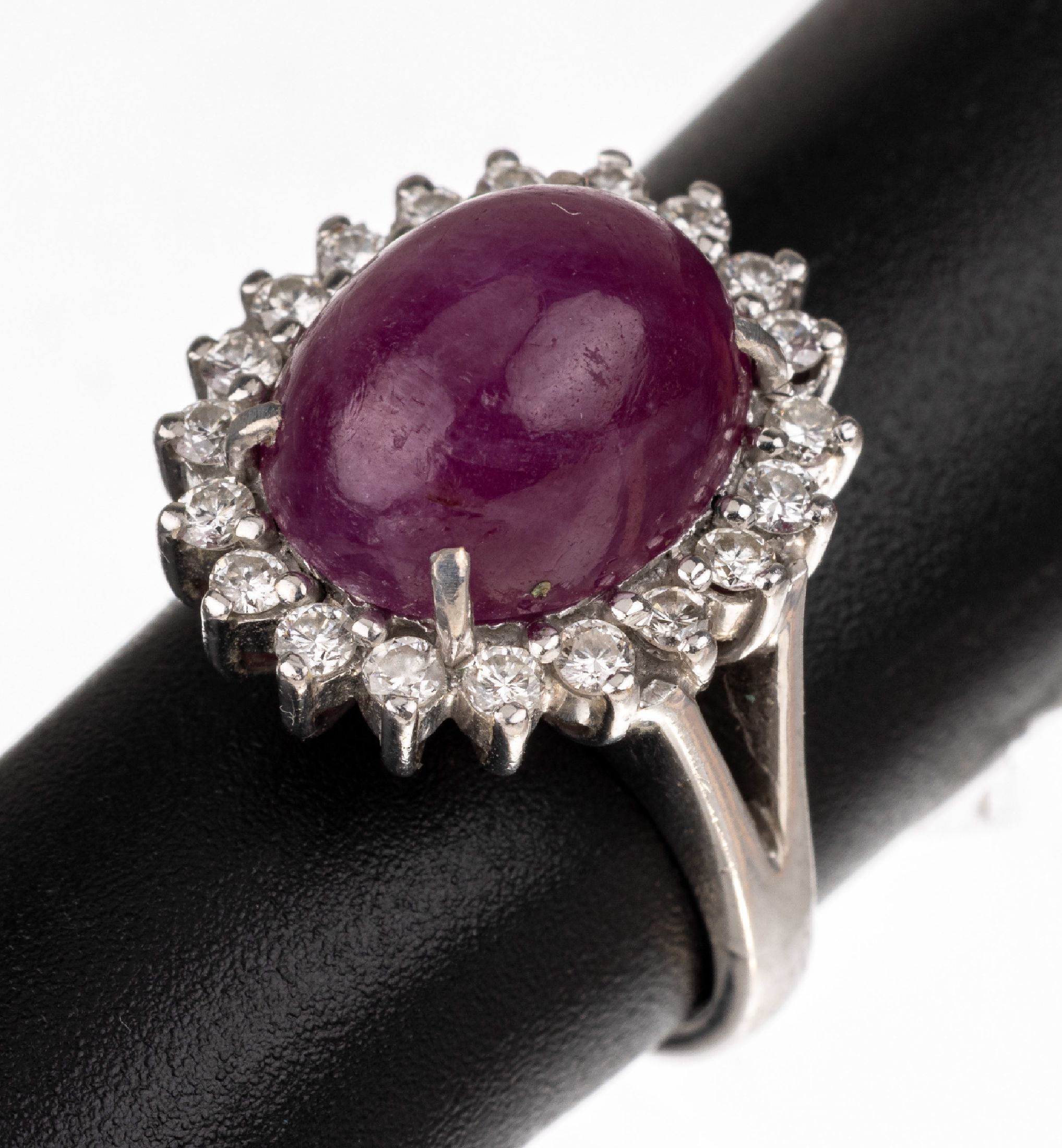 14 kt Gold Rubin-Brillant-Ring, WG 585/000, ovaler Rubin-Cabochon ca. 4.0 ct, 20 Brillanten zus. ca. 0.40 ct feines Weiß -Weiß/lr-vs, RW 46, total ...