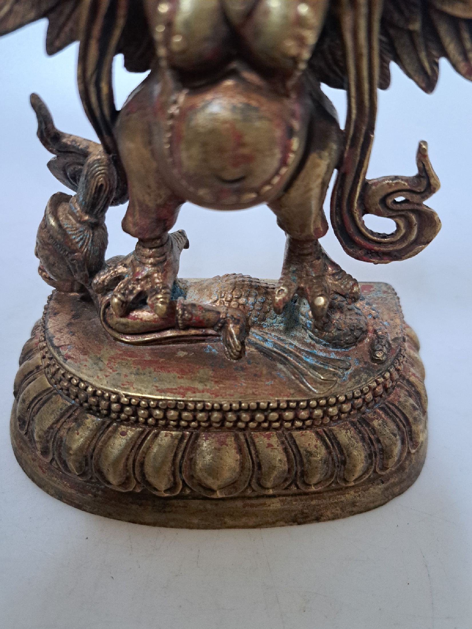 Detail b: Bronzeskulptur, Garuda, Tibet, 20. Jh., Lotussockel, ca. 18 x 16 cm, Reste von ehemaliger Fassung