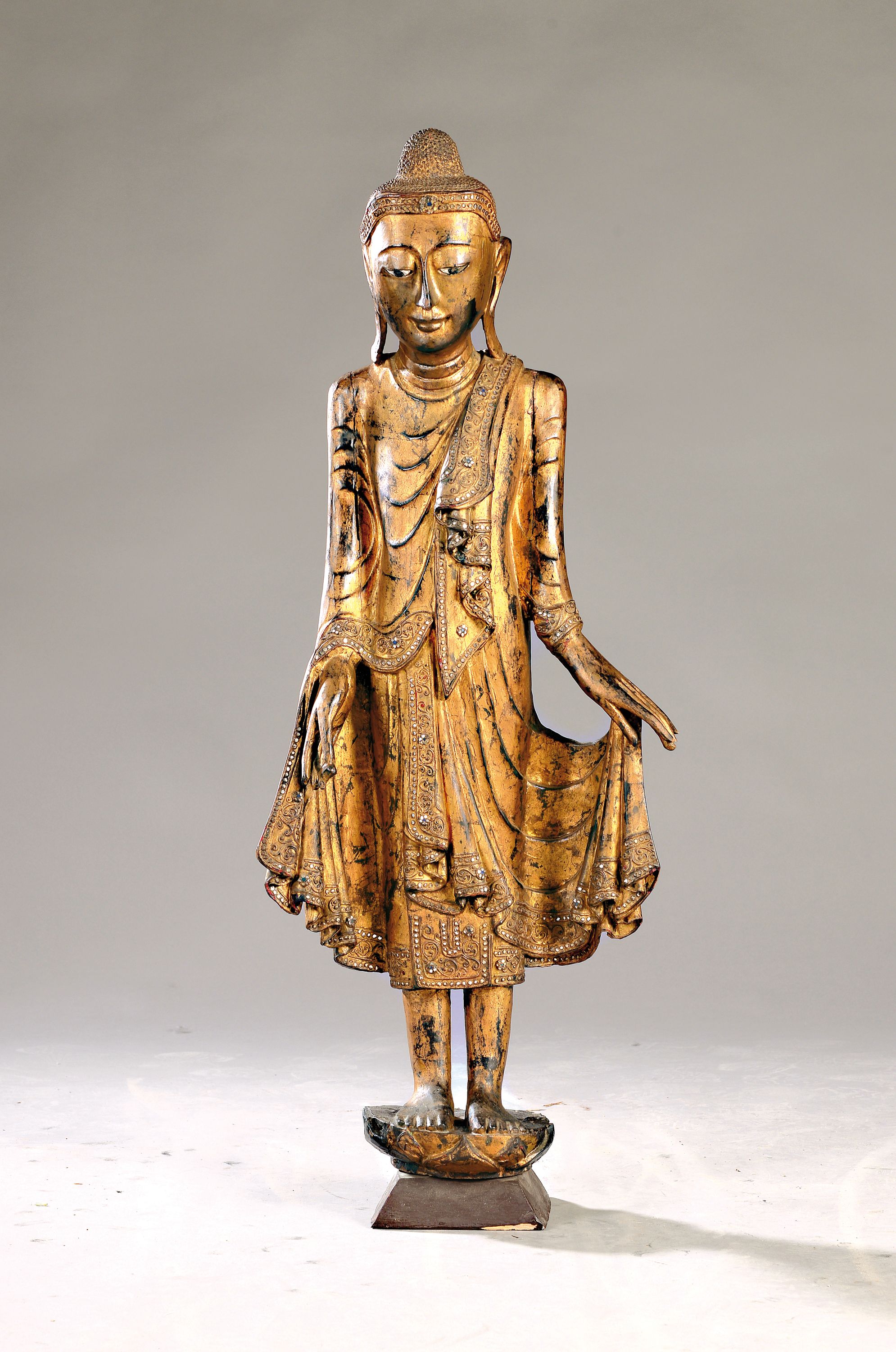 Großer stehender Buddha, Burma, Anfang 20. Jh., Holz geschnitzt, mit Spiegeleinsätzen, gefaßt, leicht beschädigt, H. ca. 103 cm
