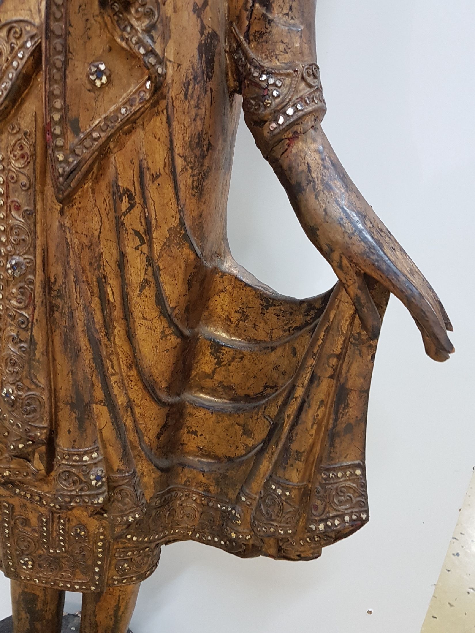 Detail e: Großer stehender Buddha, Burma, Anfang 20. Jh., Holz geschnitzt, mit Spiegeleinsätzen, gefaßt, leicht beschädigt, H. ca. 103 cm