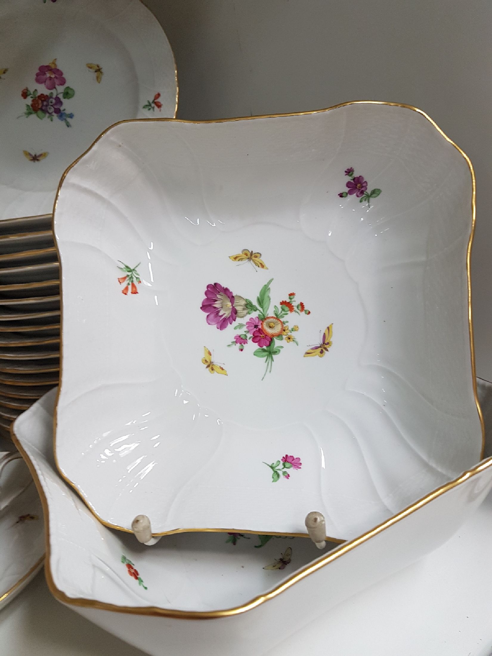Detail c: Tafelservice/Speiseservice für 12 Personen, KPM Neuosier, 20. Jh., Blumenmalerei und Schmetterlingen bemalt, Goldränder, 12 Menueteller D. 26 cm, ...