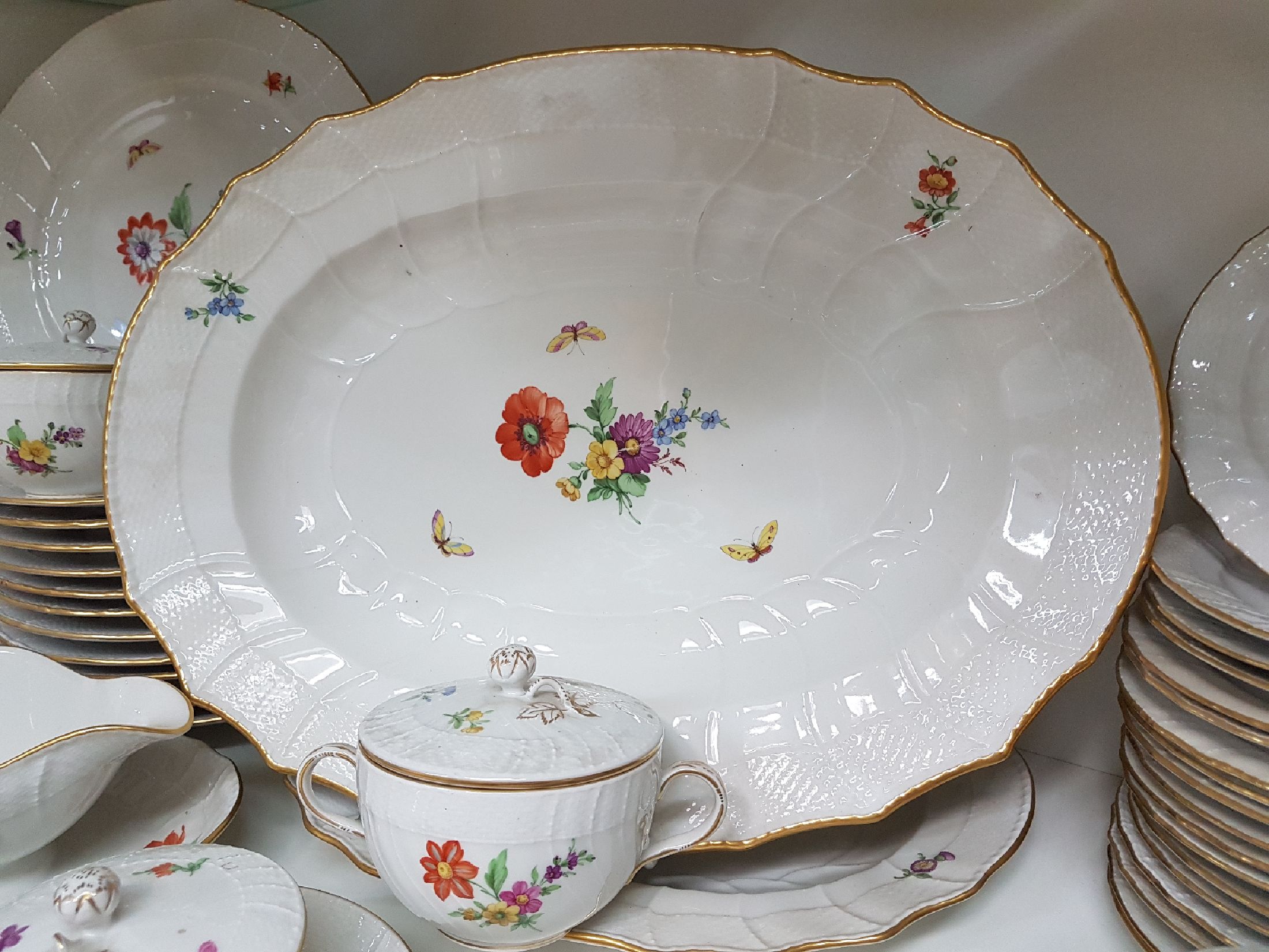 Detail f: Tafelservice/Speiseservice für 12 Personen, KPM Neuosier, 20. Jh., Blumenmalerei und Schmetterlingen bemalt, Goldränder, 12 Menueteller D. 26 cm, ...
