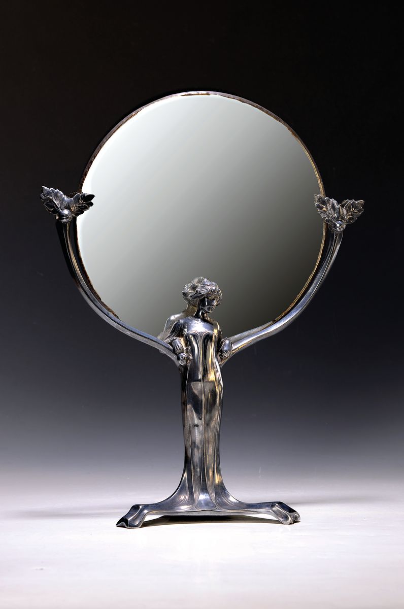 Tisch-Spiegel, Frankreich, um 1900, Metall, in Form einer vollplastischen Frauenfigur, rundes facett. Spiegelglas, Altersspuren, H. ca. 42cm