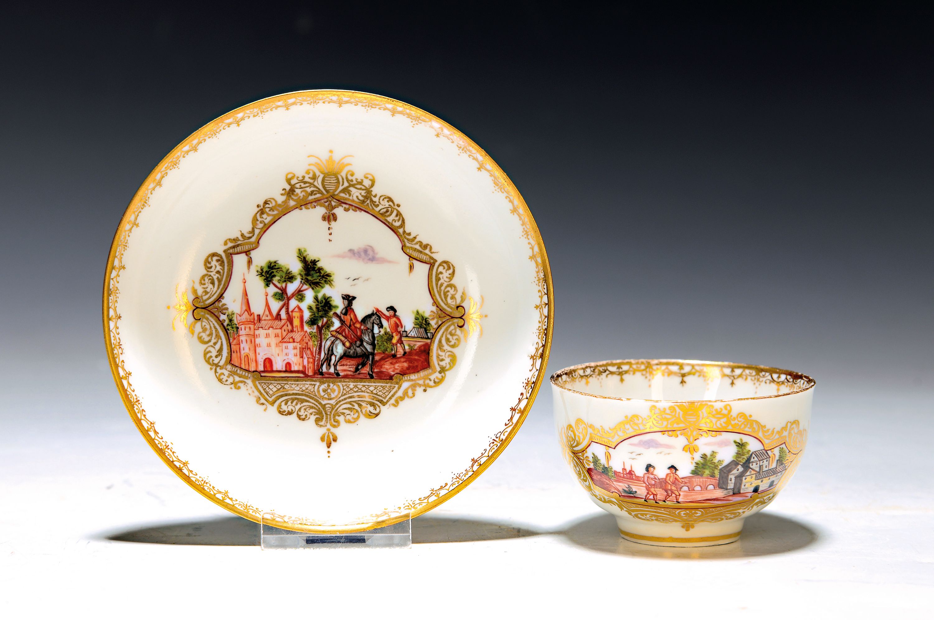 Tasse mit Untertassen, Meissen, um 1740/50, Porzellan, in Goldreserven Stadt- bzw. Schlossansicht mit Reiter bzw. Personen, Goldspitzendekor, Tasse ...