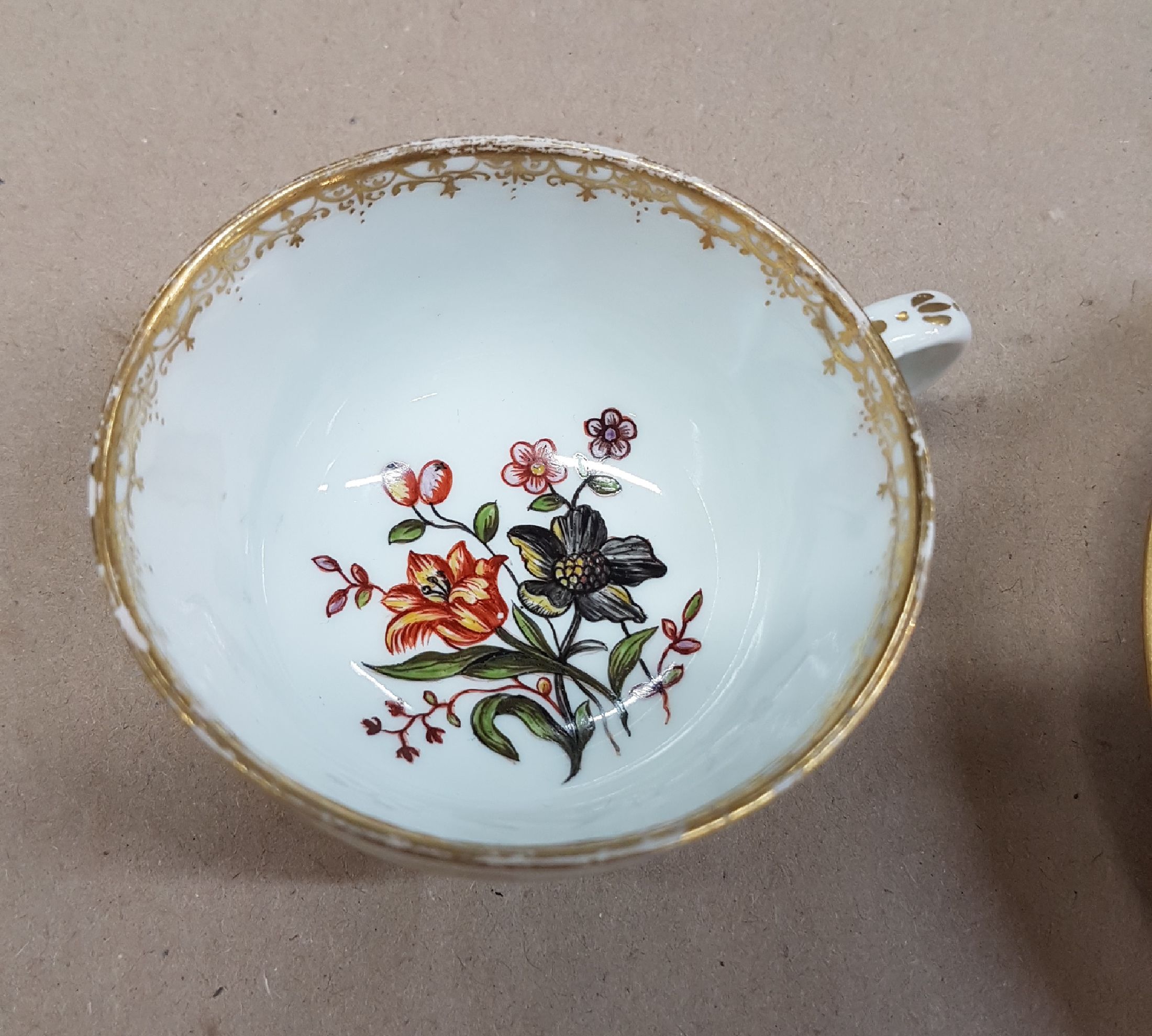 Detail b: Tasse mit Untertassen, Meissen, um 1740/50, Porzellan, in Goldreserven Stadt- bzw. Schlossansicht mit Reiter bzw. Personen, Goldspitzendekor, Tasse ...
