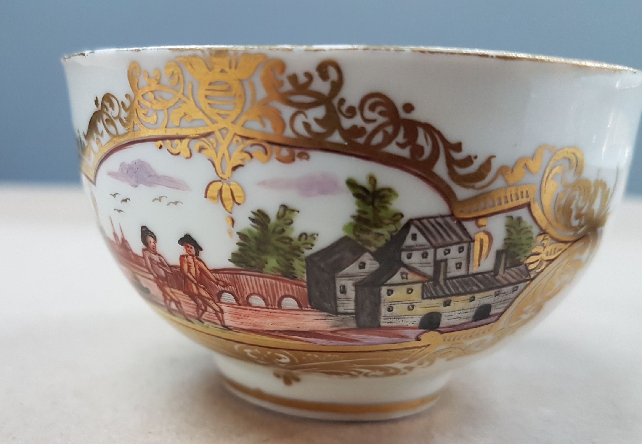 Detail c: Tasse mit Untertassen, Meissen, um 1740/50, Porzellan, in Goldreserven Stadt- bzw. Schlossansicht mit Reiter bzw. Personen, Goldspitzendekor, Tasse ...