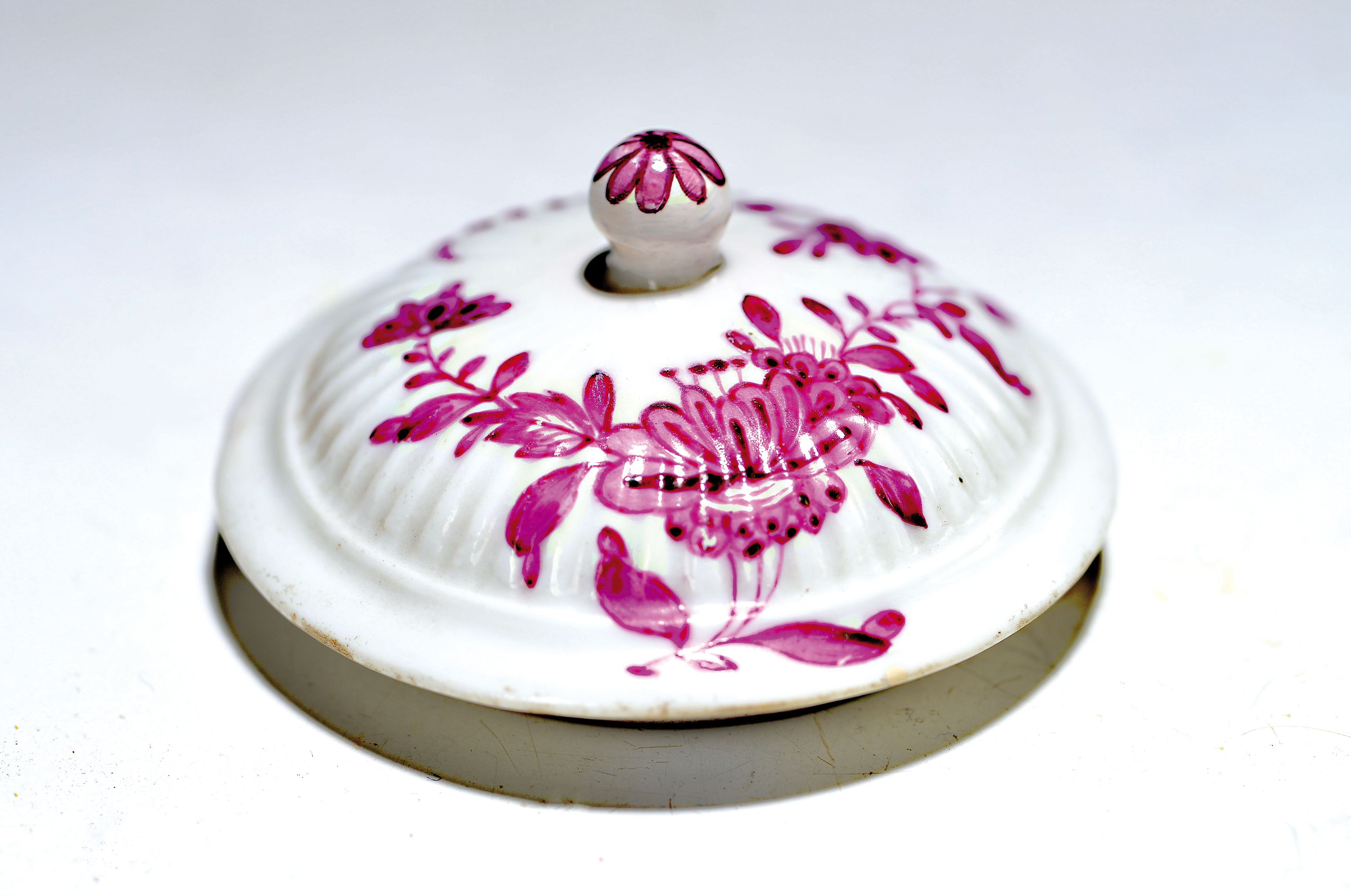 Ersatz-Deckel, Meissen 18. Jh, leicht gewölbte Form, mit Rippendekor, purpurfarbene Bemalung, ind. Blumen, D. ca. 5.8 cm
