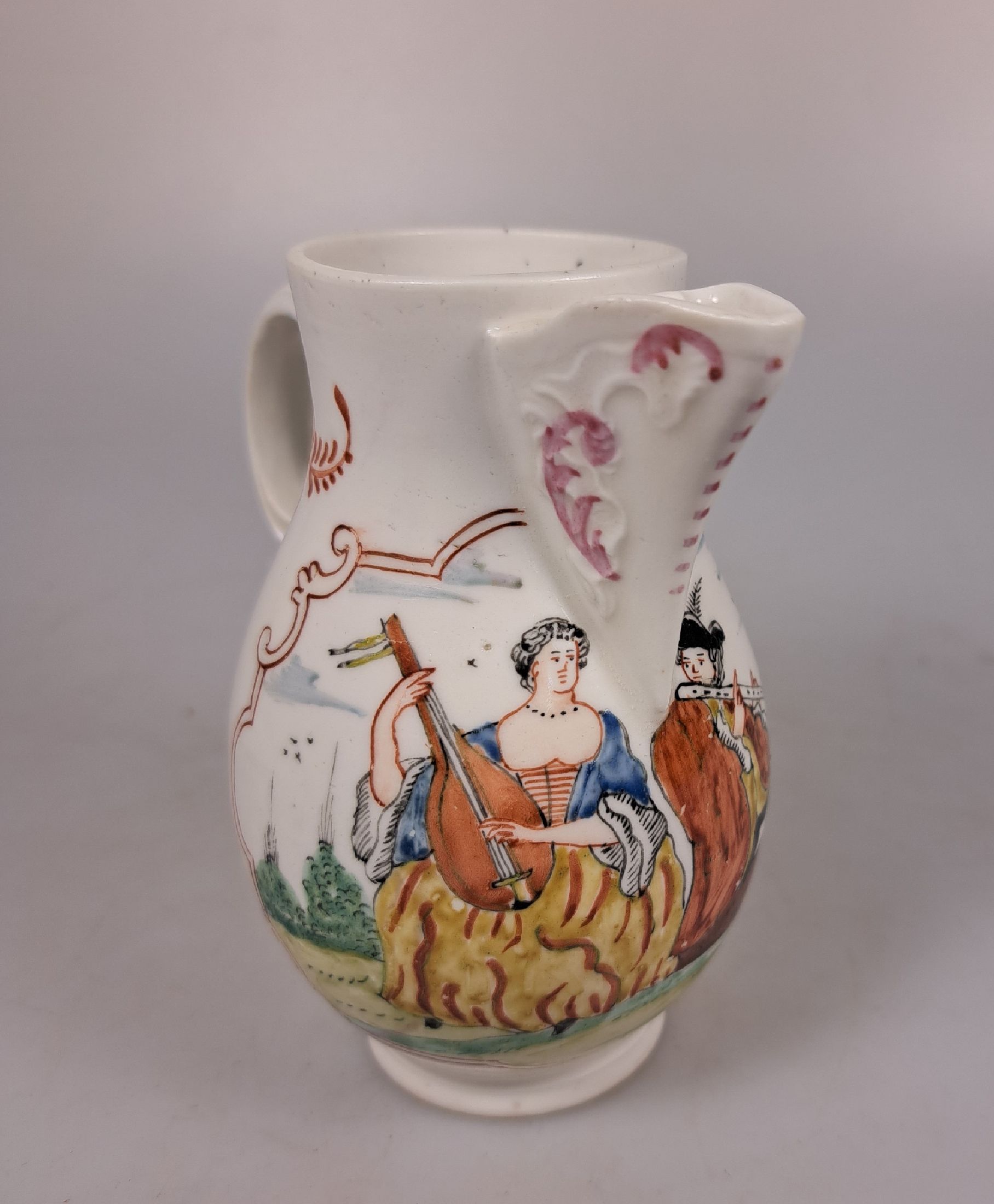 Detail e: Kännchen, wohl Höchst um 1760, polychrom bemalt, musizierendes Paar, ohne Marke, ohne Deckel, Milchkännchen, H. ca. 11 cm