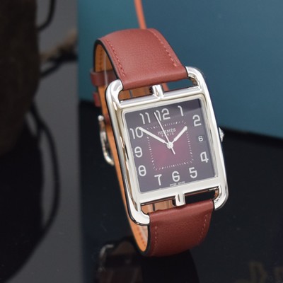 26714933b - HERMES wristwatch series Cape Cod reference CC1.810, stainless steel case including original leather strap with original buckle, quartz, case back 6-times screwed, red dial with Arabic hours, display of hours, minutes, sweep seconds & date, measures approx. 33 x 46 mm, Hermes storage back enclosed, unworn stock, condition 1-2