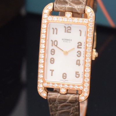 26714969a - HERMES ladies wristwatch series Nantucket reference NA2.271, 18k pink gold including original leather strap with original 18k pink gold buckle, quartz, case back screwed-down 4 -times, case at the sides lavish diamonds set, mother of pearl dial, display of hours & minutes, measures approx. 37 x 20 mm, Hermes storage back enclosed, unworn stock, condition 1-2