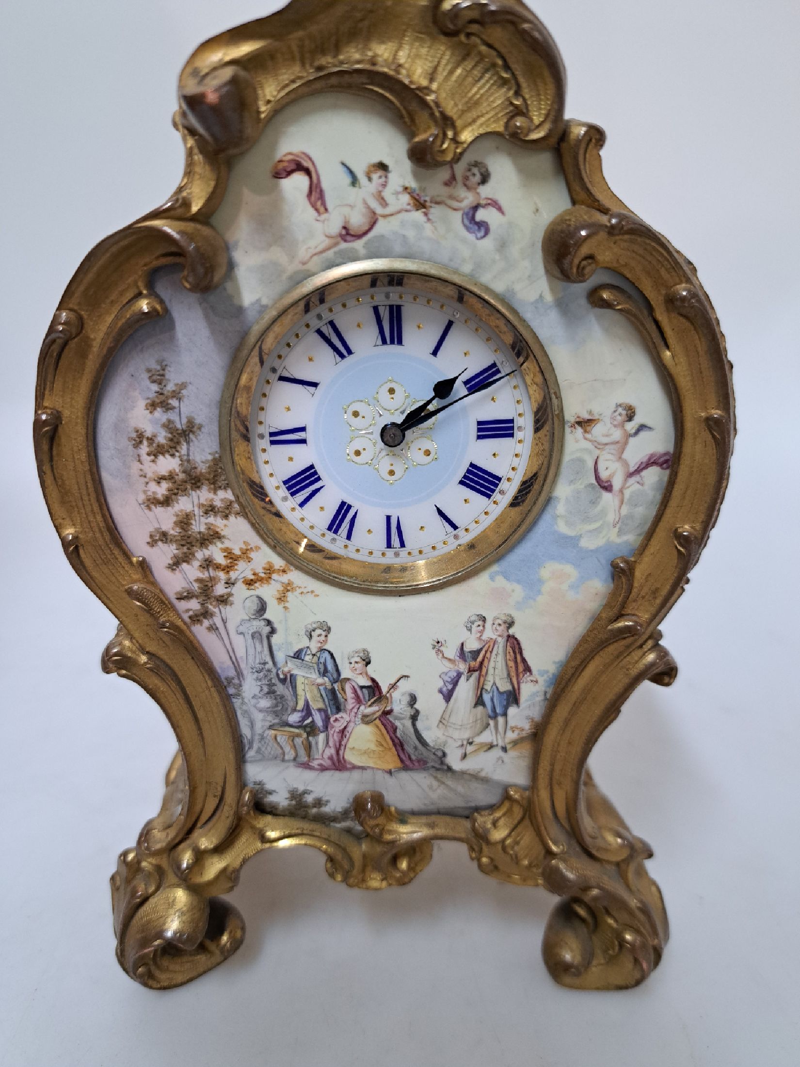 Detail a: kleine elegante Tischuhr, Frankreich um 1860/70, im Stil des Rokoko, verziertes Bronzegehäuse (ehem. vergoldet - berieben), dreiseitig mit Porzellan ...