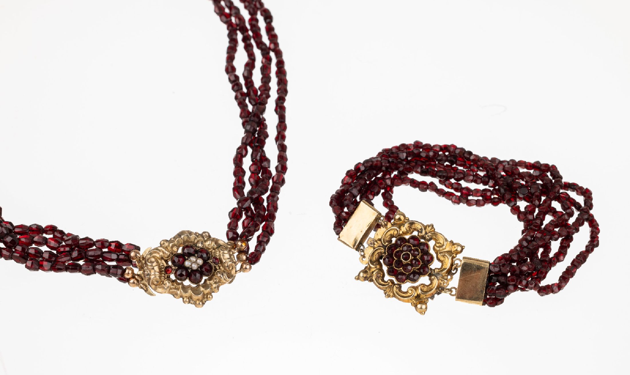 Konvolut 2 Biedermeierschmuckstücke, um 1850/60, Schaumgold, best. aus: 4-reihiges Collier und 7-reihiges Armband, facett. Granate, Schließen mit ...