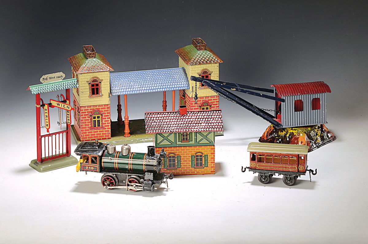Eisenbahn mit Bahnhof und Zubehör, Bing, um 1906, Spur 0, Komplettpaket mit Lokomotive mit Tender, zwei Personenwagen, zwei Güterwagen, sowie ...