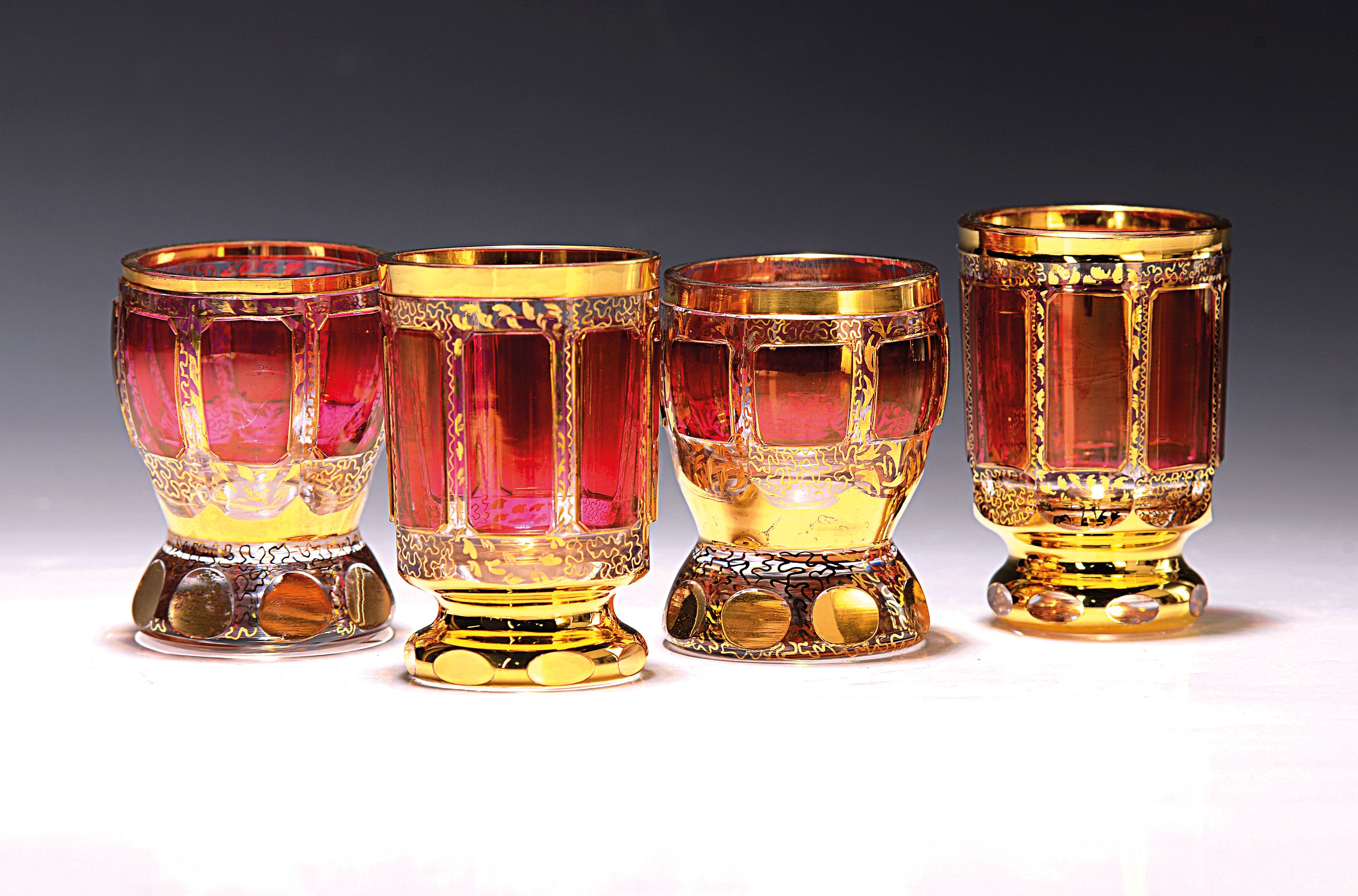 21 Gläser, Böhmen, Mitte 20. Jh., 13 kleine Pokalgläser und 8 kl. Bechergläser, farbloses Glas, rubinierte Felder, Goldstaffage, H. ca. 8/8.5 cm
