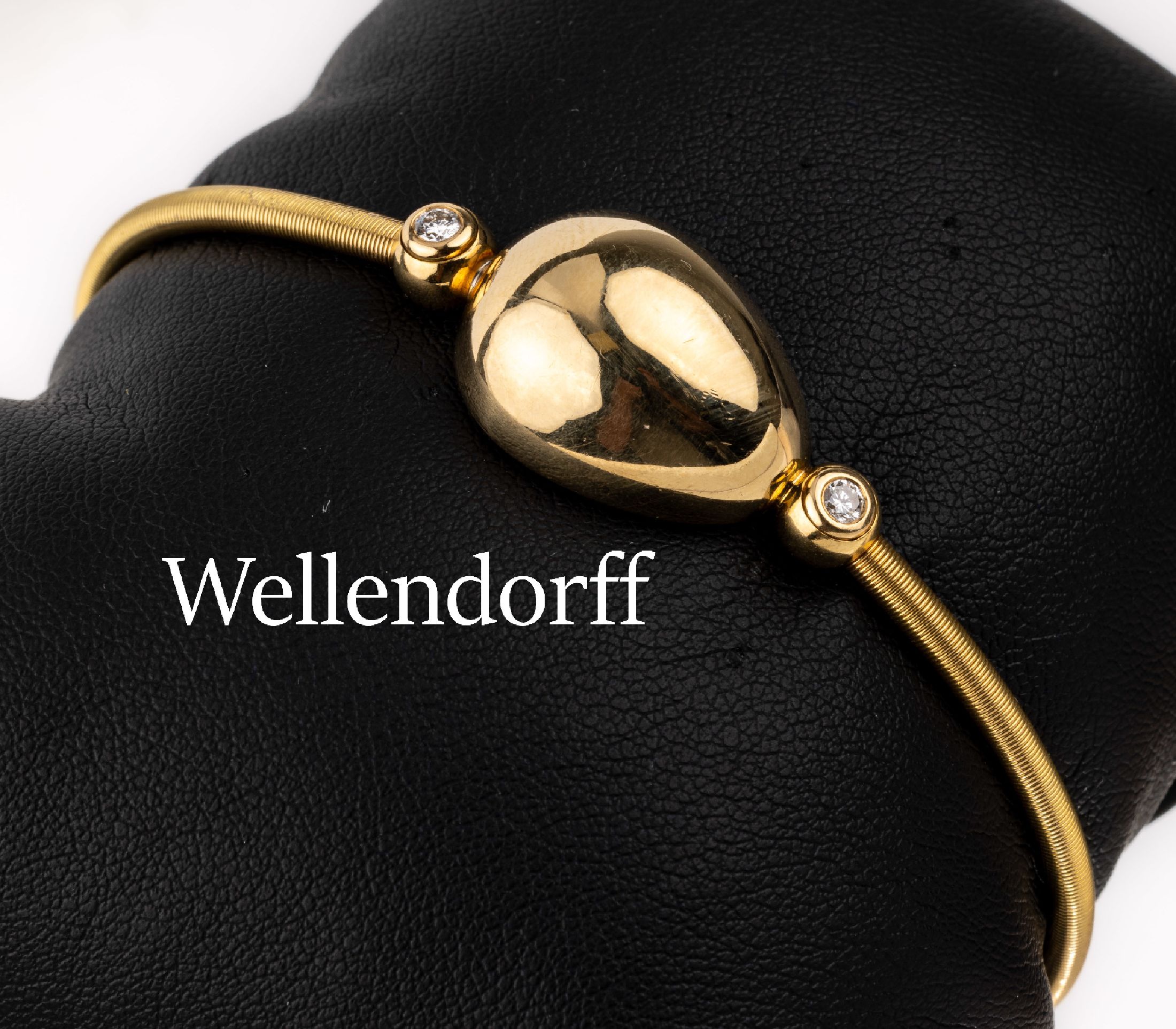 18 kt Gold WELLENDORFF Brillant-Armspange, GG 750/000, tropfenf. Mittelteil, seitl. bes. mit 2 Brillanten zus. ca. 0.15 ct feines Weiß/vs, Reif ...