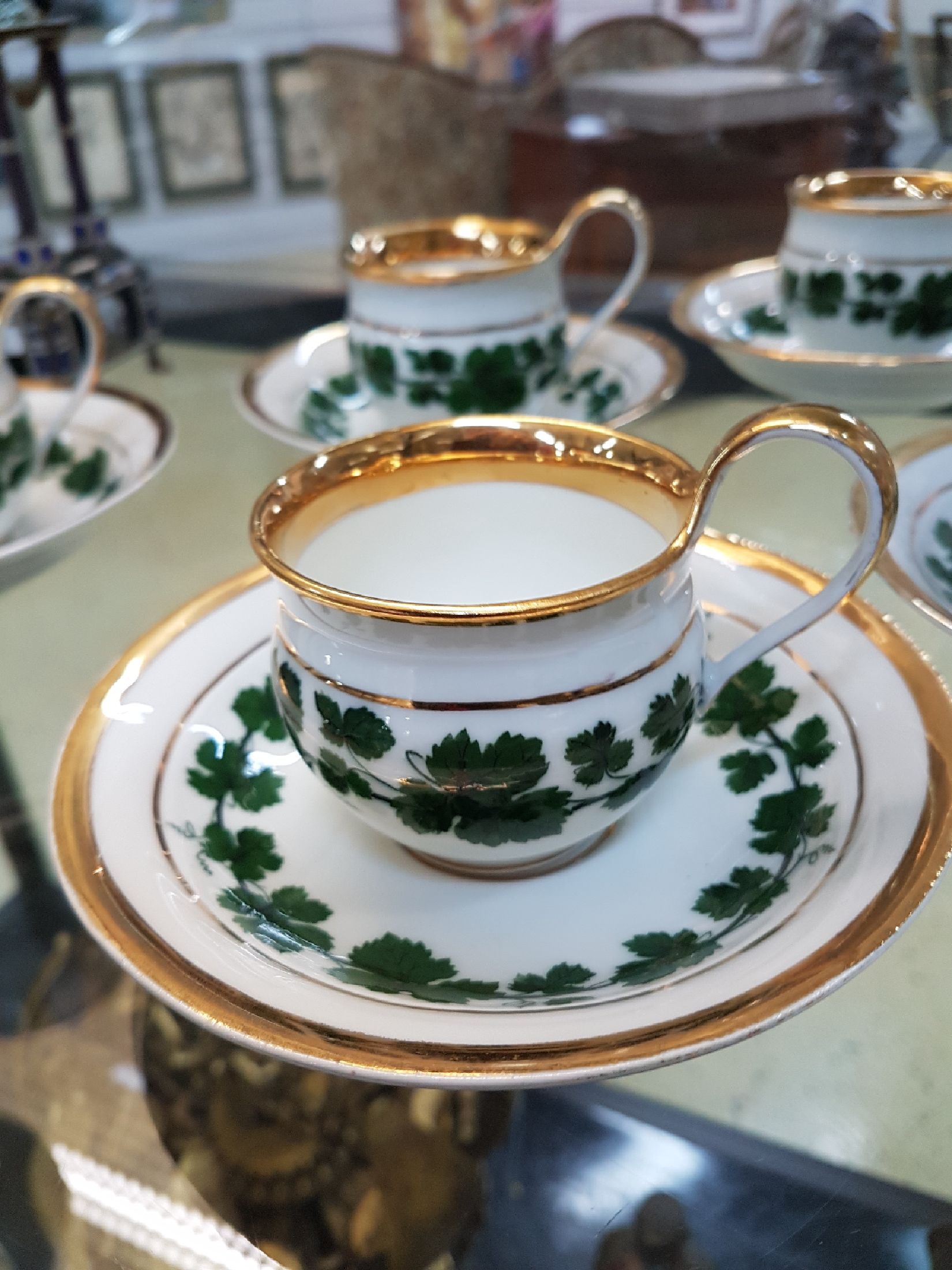 Detail a: 6 kleine Tassen mit Untertassen, Meissen, um 1890-1900, Porzellan, Dekor grüner Weinkranz, breite Glanzgoldränder, leicht berieben, eine Untertasse ...