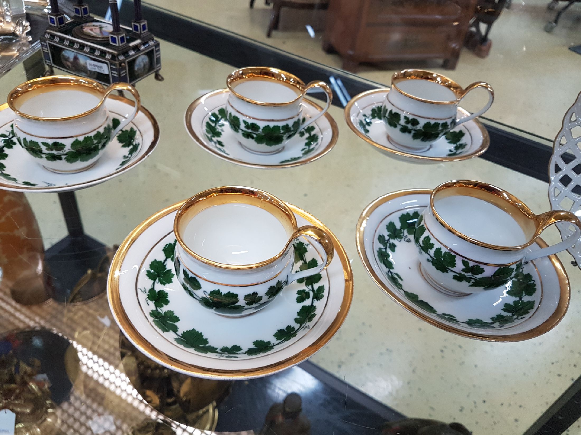 Detail b: 6 kleine Tassen mit Untertassen, Meissen, um 1890-1900, Porzellan, Dekor grüner Weinkranz, breite Glanzgoldränder, leicht berieben, eine Untertasse ...