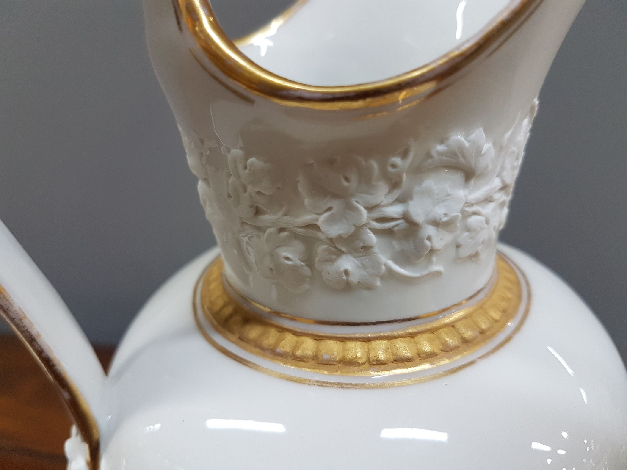Detail l: Kanne, Kgl. Kopenhagen, 1. Hälfte 19. Jh., Porzellan, weiß glasiert, mit aufgelegten Appliken aus Biskuitporzellan, Maskerone und Weinlaubfriese ...