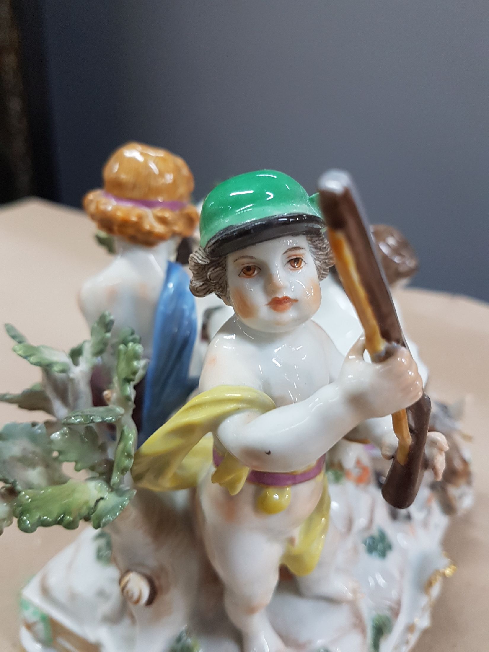 Detail e: Seltener Tafelaufsatz mit Putten, Meissen, um 1900, zentrale Muschelschale auf Felsen, umgeben von drei Putten mit jagdlichen Attributen: zwei mit ...