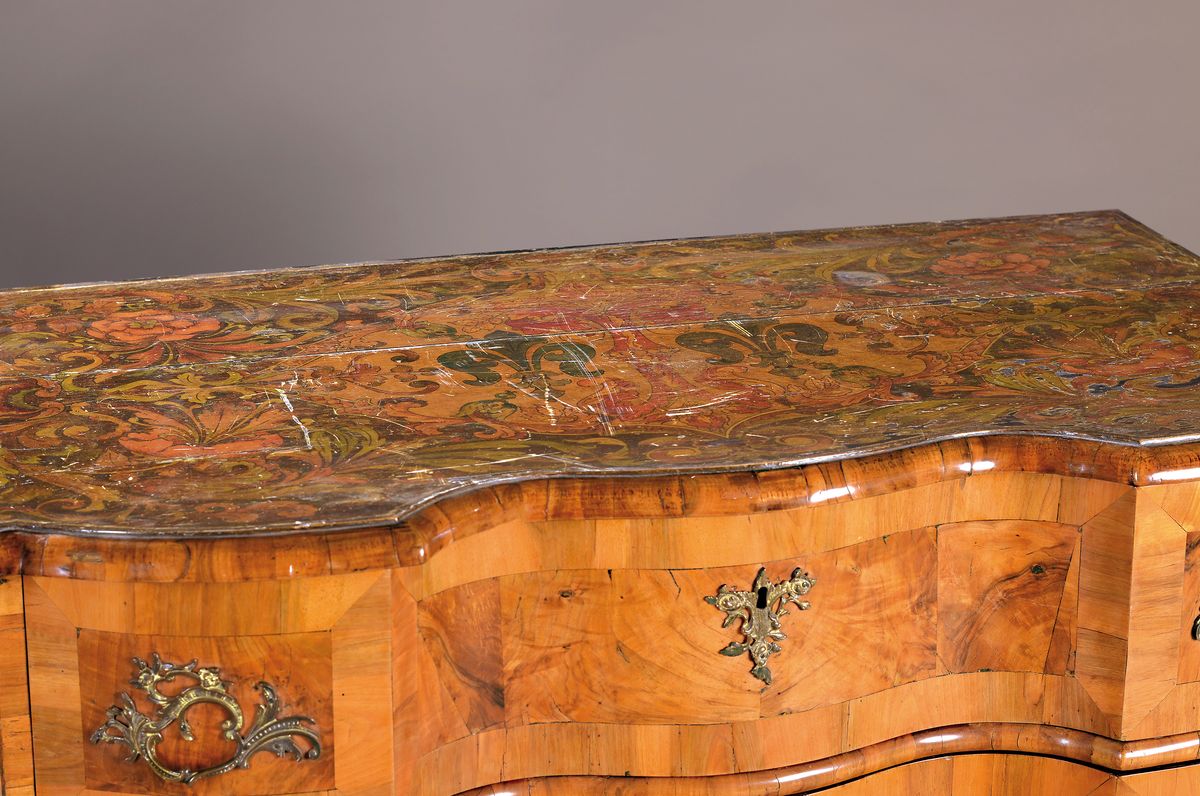 Detail a: Kommode, Barock, wohl Niedersachsen um 1760,Wurzelfurnier, z.T. Wurzelnuss, dreifach geschweift, drei Schubladen, Platte mit orig. Brandmalerei, ...