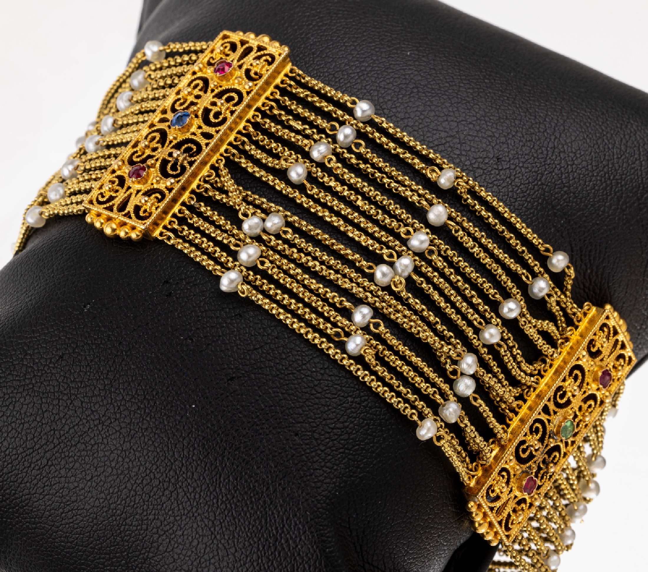 18 kt Gold Armband, GG 750/000 gepr., 15 Reihen mit kl. barocken Zuchtperlen, 3 Zwischenglieder, geschwungen durchbrochen gearbeitet, mit kl. synth. ...